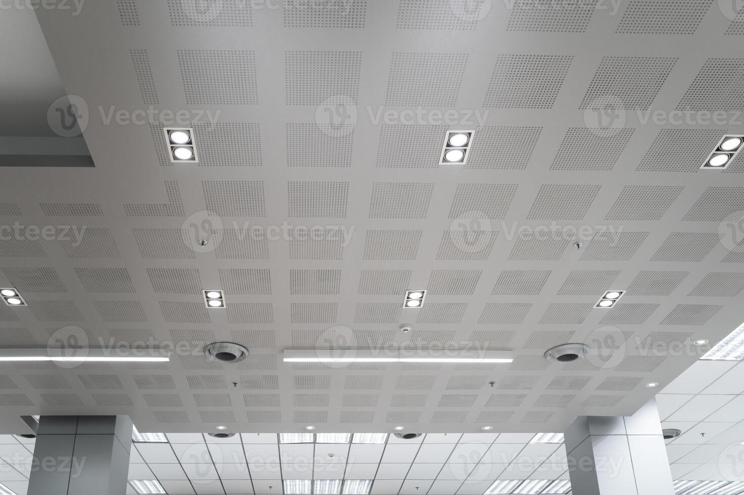 Ceiling mounted cassette type air conditioner and modern lamp light on white ceiling. Duct air conditioner for home, hall or office. photo