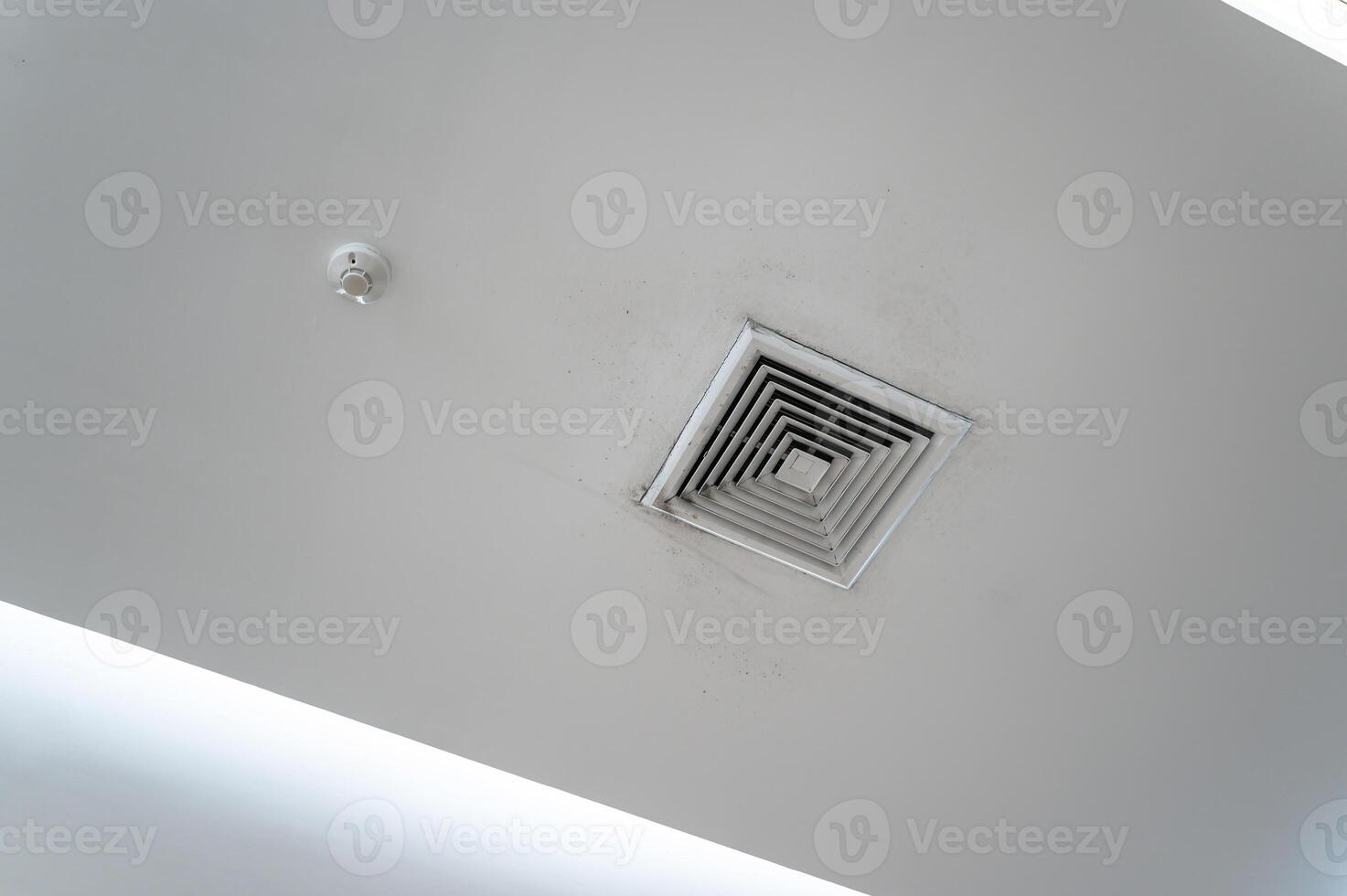 Ceiling mounted cassette type air conditioner and modern lamp light on white ceiling. Duct air conditioner for home, hall or office. photo