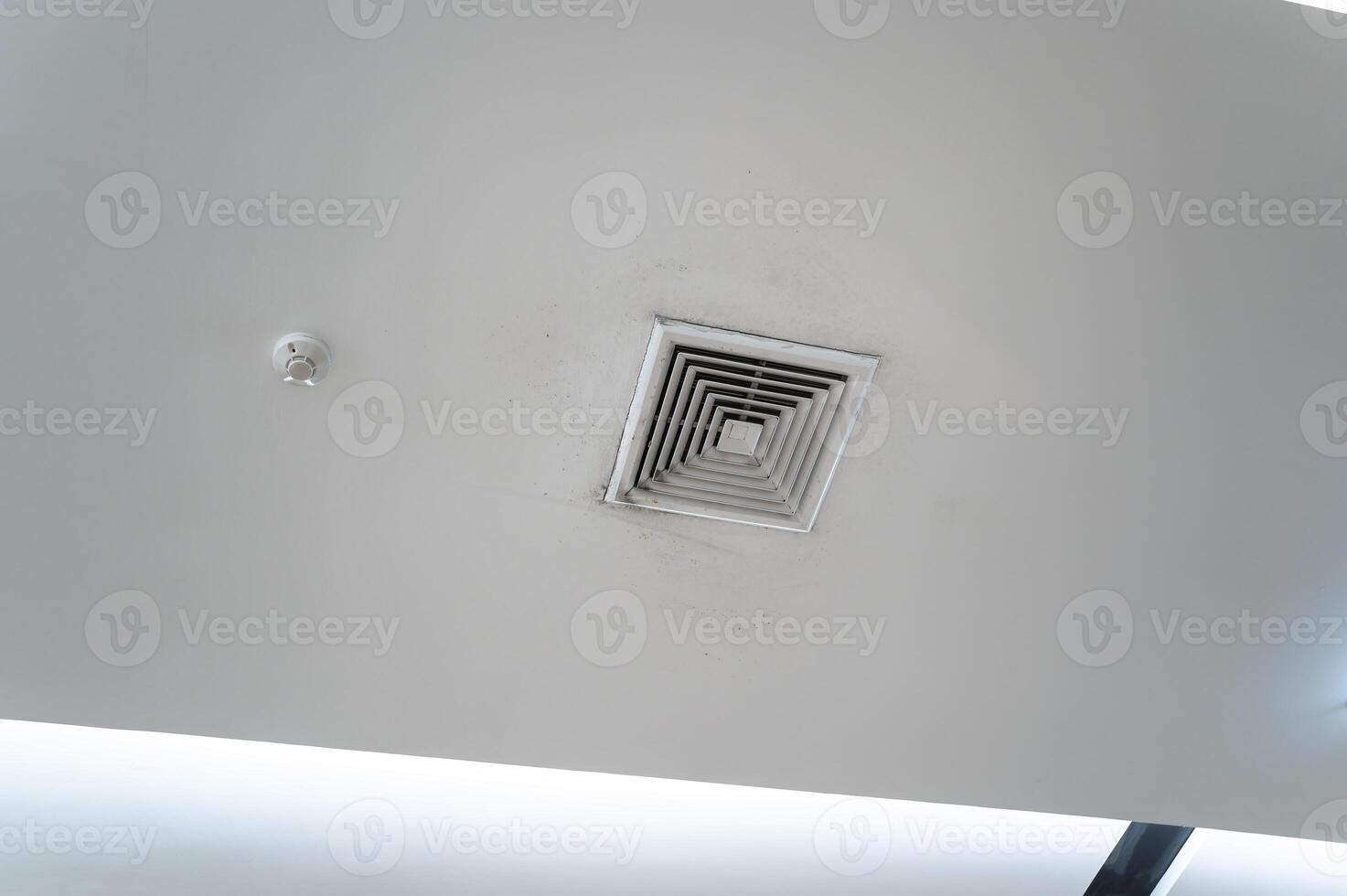 Ceiling mounted cassette type air conditioner and modern lamp light on white ceiling. Duct air conditioner for home, hall or office. photo