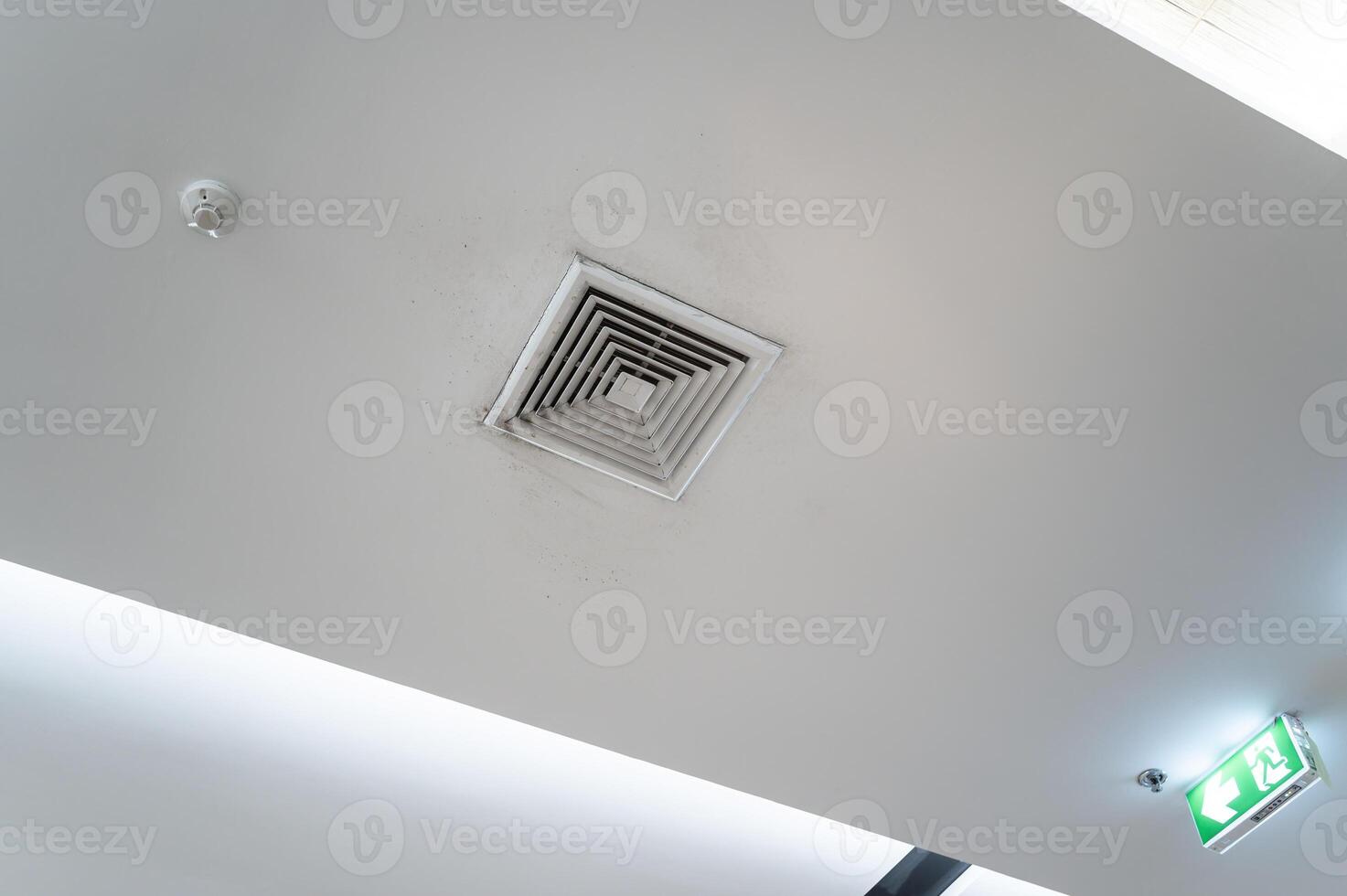 Ceiling mounted cassette type air conditioner and modern lamp light on white ceiling. Duct air conditioner for home, hall or office. photo