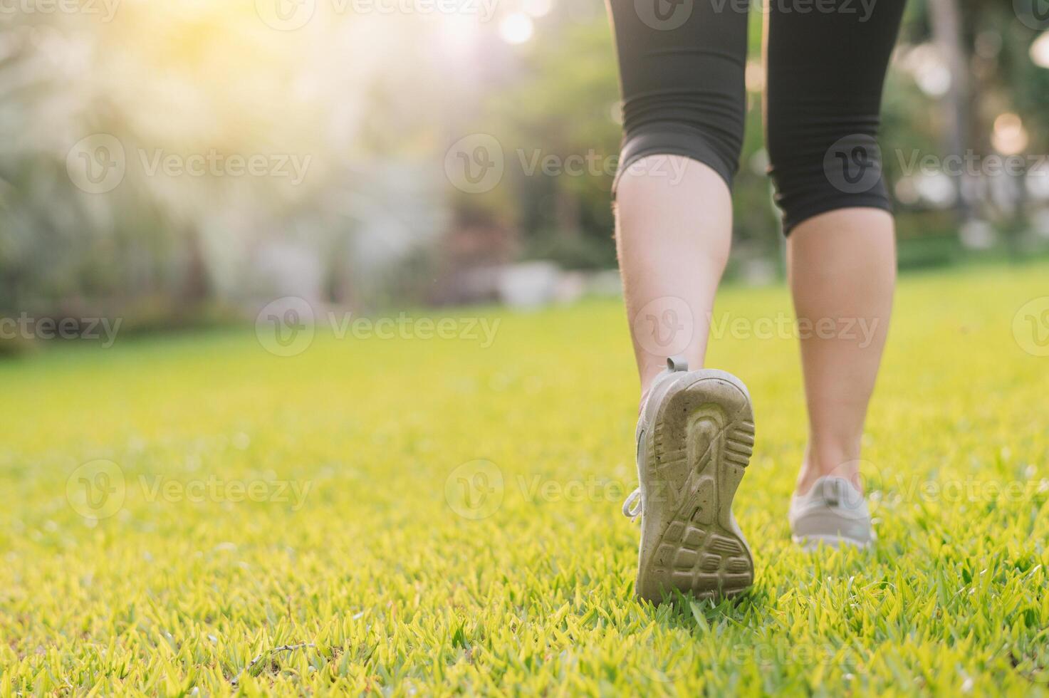 jogger woman. close up person training sport runner young female shoe on grasses in public park. fitness leg and foot exercise athlete. marathon in nature. active healthy lifestyle workout concept. photo