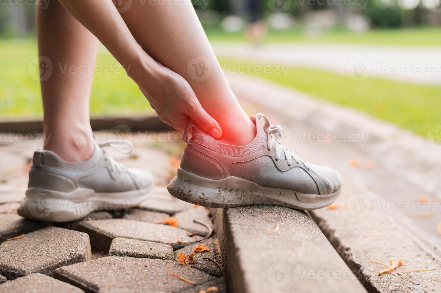 Relief for female joggers dealing with post-run pain. Specialized care for ankle injuries in the public park. Get back on track with treatment concept. photo