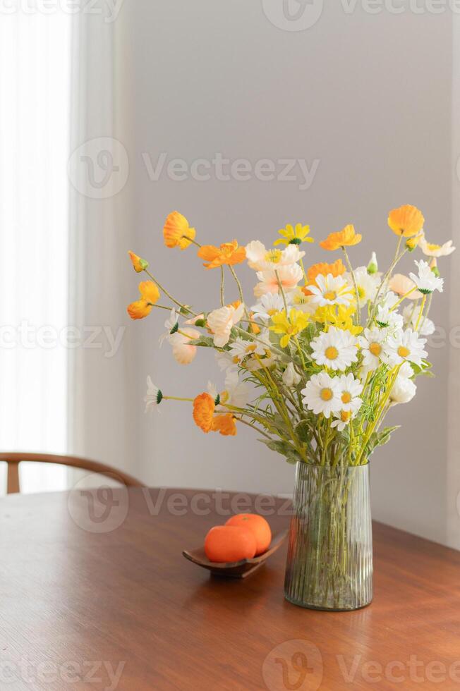 acogedor y elegante hogar interior con moderno mueble y elegante decoración. añadir toque de naturaleza con naranja y artificial floral ramo de flores en un blanco florero. lujo y relajación en residencial concepto. foto