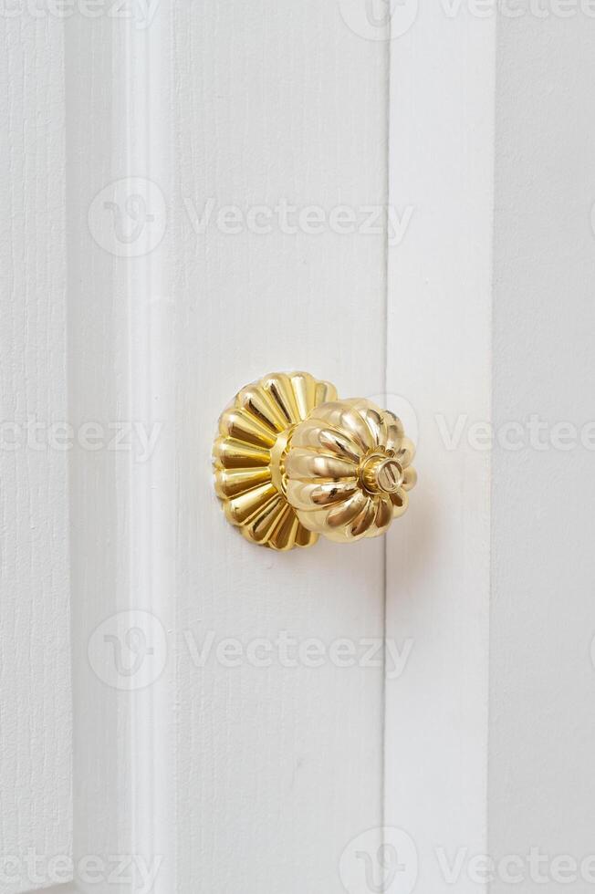 gold door knob handle. reflective surface and modern design add touch of luxury to entrance door. Crafted with metal and wood, this round knob shines with style and security. photo