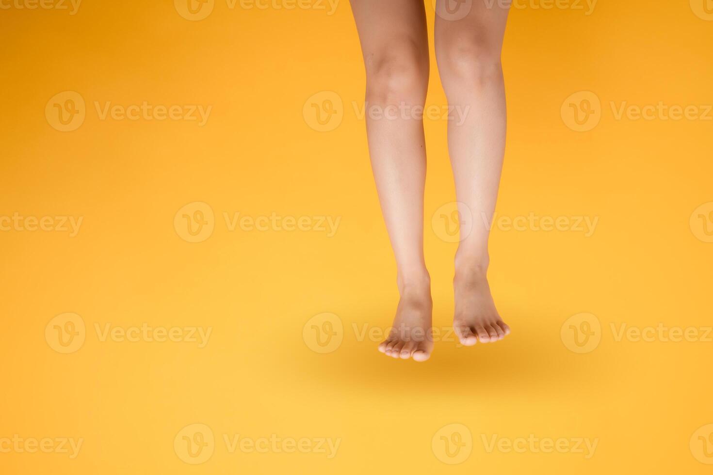 Indulge in the luxurious sensation of velvety foot touch with a 30s person's elegant close up on vibrant yellow backdrop. photo
