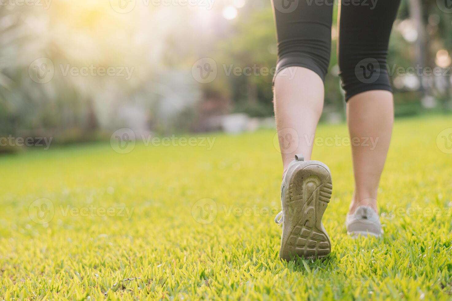 jogger woman. close up person training sport runner young female shoe on grasses in public park. fitness leg and foot exercise athlete. marathon in nature. active healthy lifestyle workout concept. photo