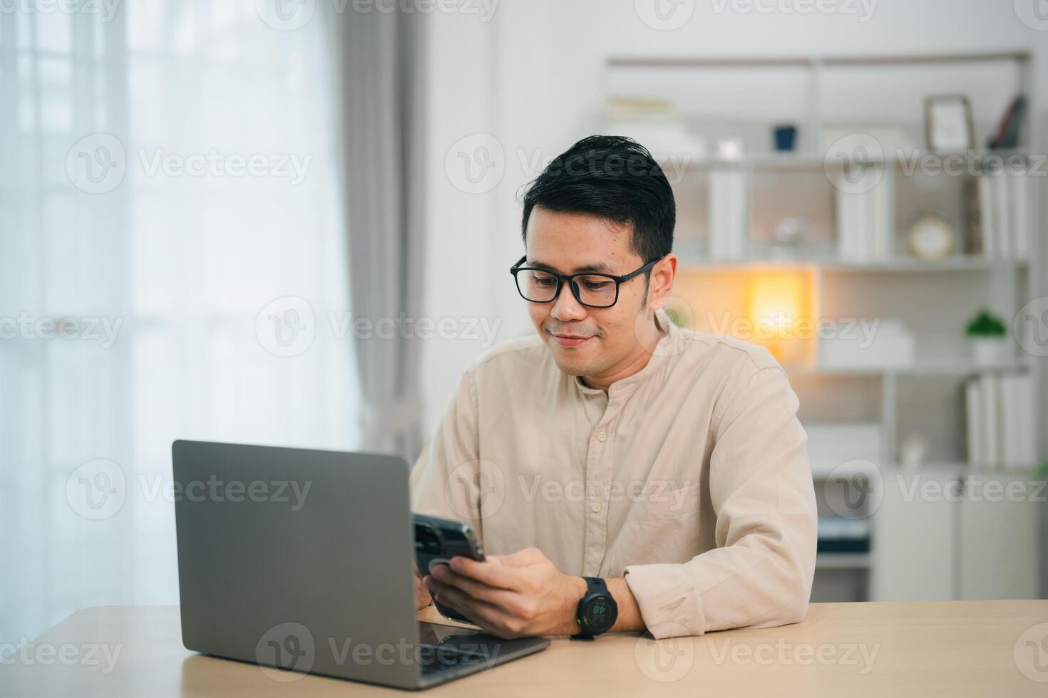 Business man smiling using smartphone on table, man using mobile phone to search or social media or shopping online or stock or crypto currency. Smart phone conversation conferrence. photo