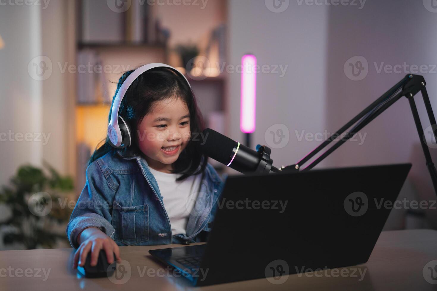 Asian influencer young girl smile using laptop live streaming greeting video conference and wearing headphone to learning online by her self. Children streaming education studying online concept. photo