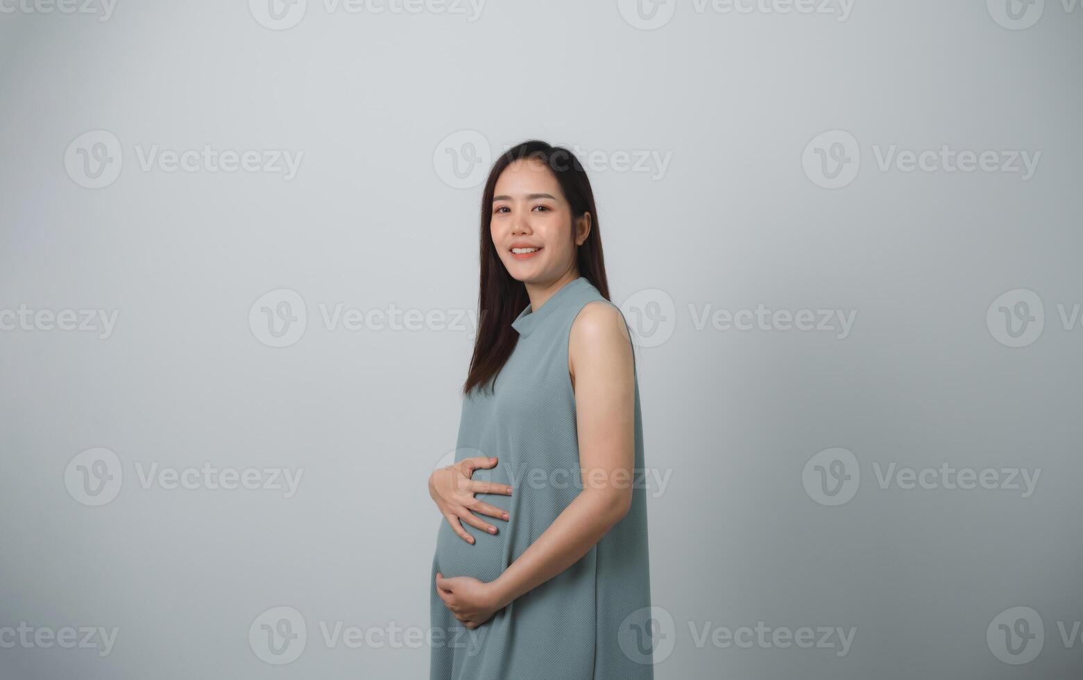 Pregnant woman holding on her belly making hand heart shape isolated on white background. Family mother mom pregnant concept. photo