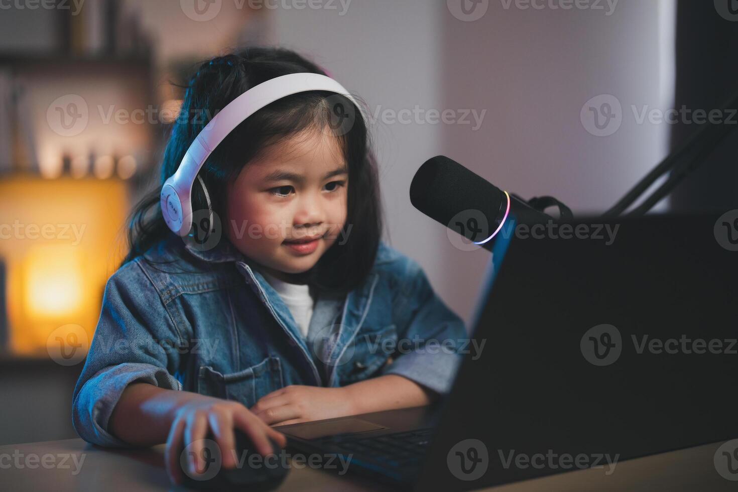 Asian influencer young girl smile using laptop live streaming greeting video conference and wearing headphone to learning online by her self. Children streaming education studying online concept. photo