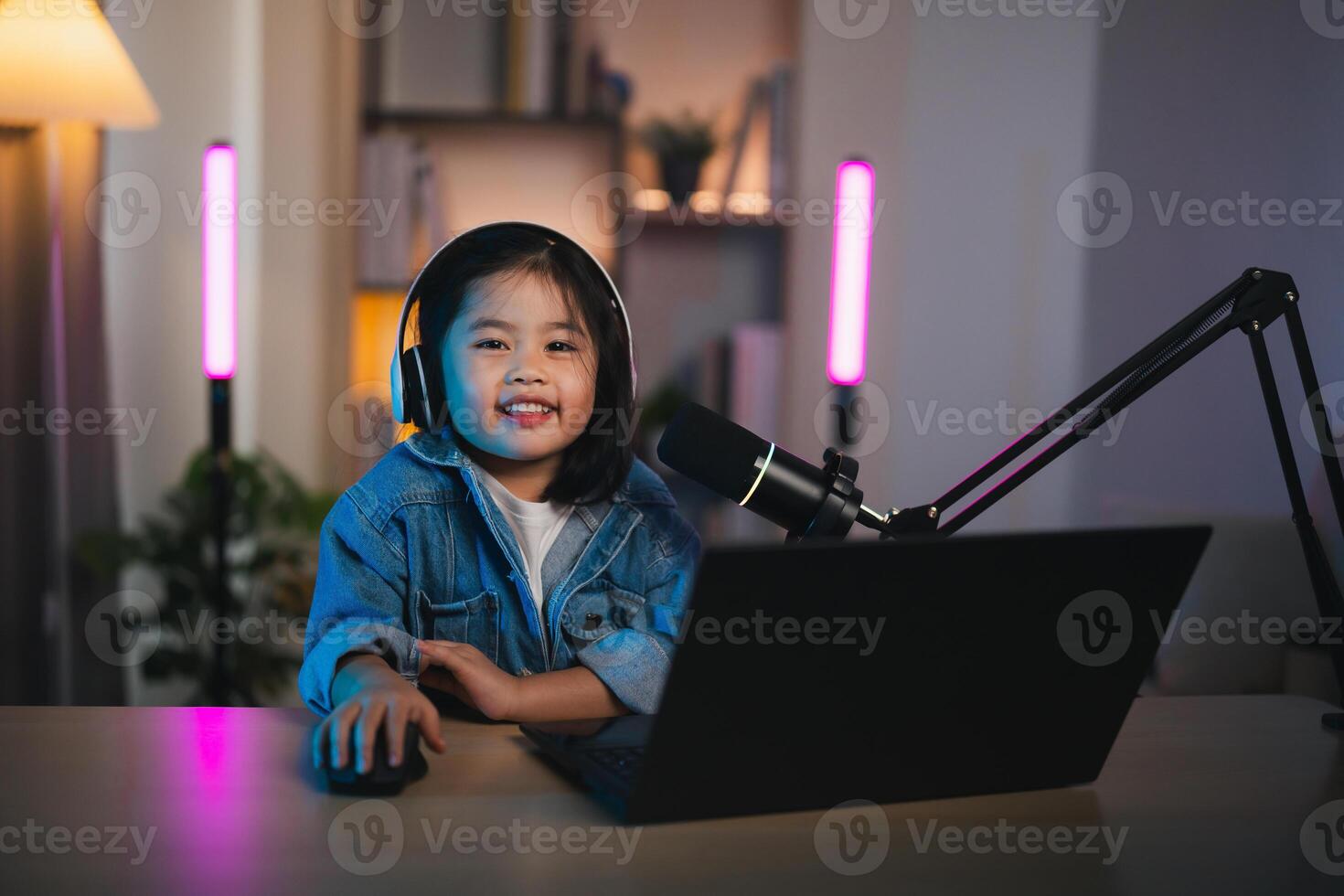 Asian influencer young girl smile using laptop live streaming greeting video conference and wearing headphone to learning online by her self. Children streaming education studying online concept. photo