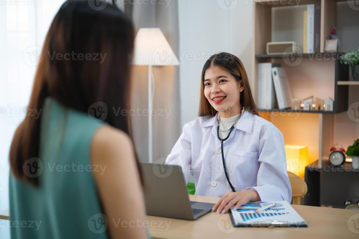 asiático profesional mujer médico hablando consultar para cuidado de la salud solución a su paciente o embarazada mujer en examen habitación a hospital o clínica. foto