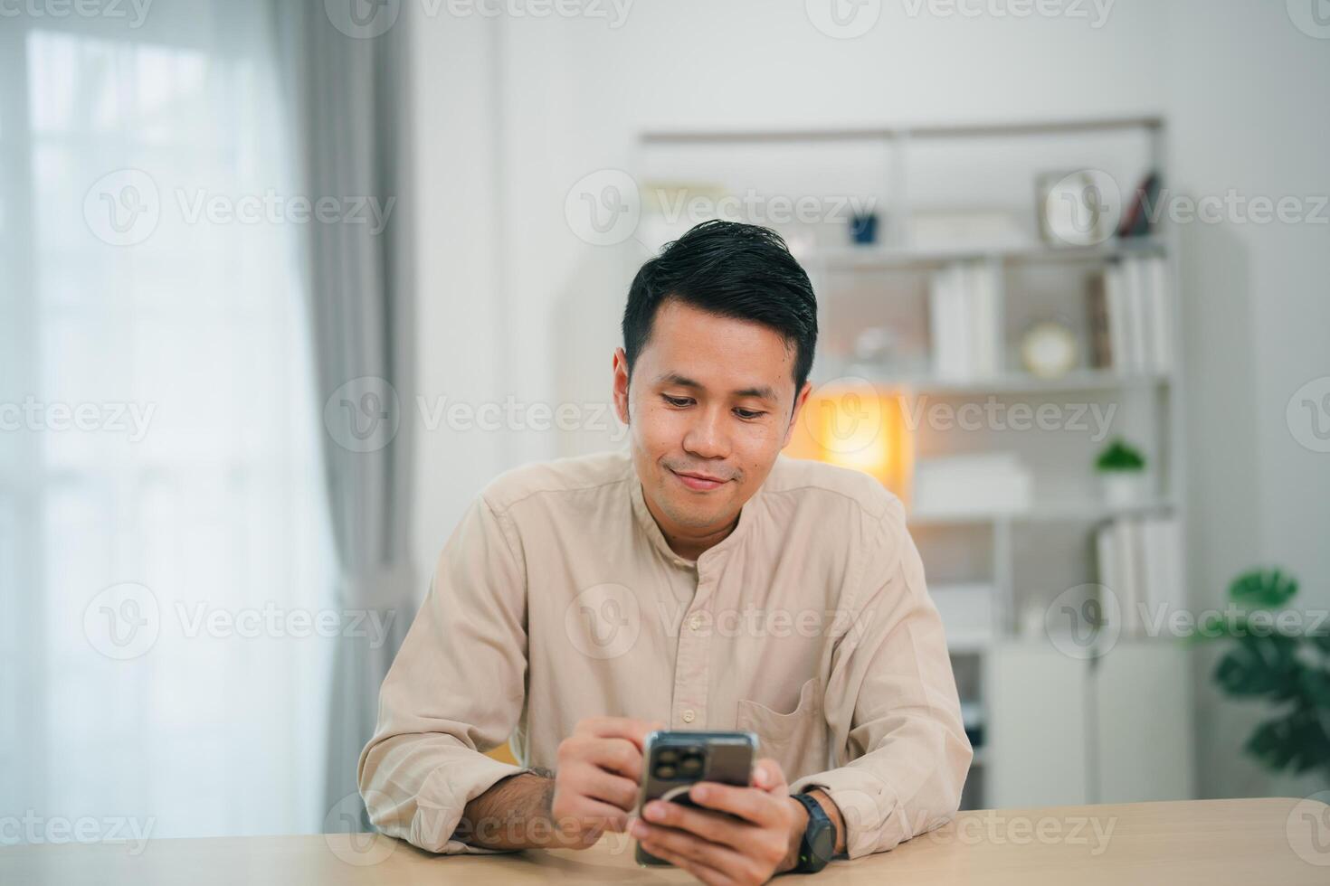 Business man smiling using smartphone on table, man using mobile phone to search or social media or shopping online or stock or crypto currency. Smart phone conversation conferrence. photo