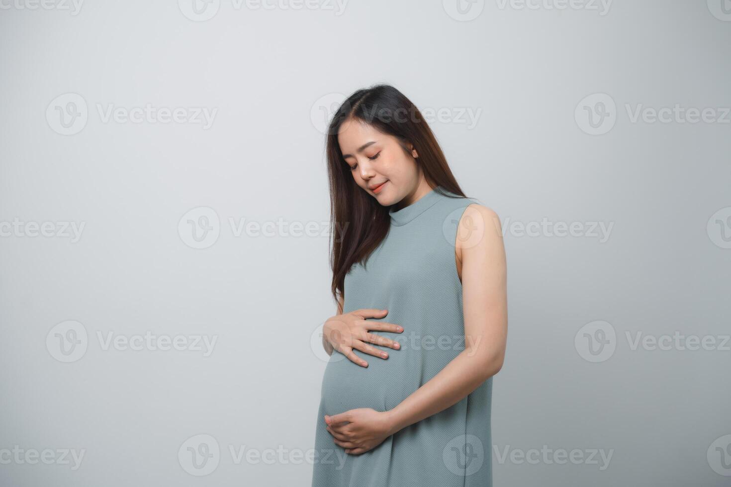 Pregnant woman holding on her belly making hand heart shape isolated on white background. Family mother mom pregnant concept. photo