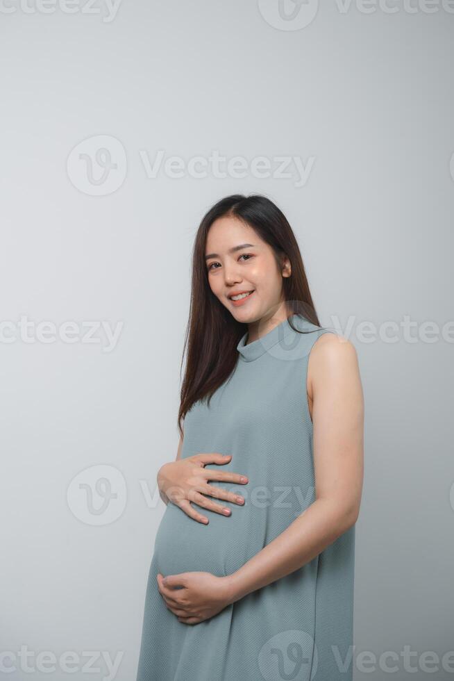 Pregnant woman holding on her belly making hand heart shape isolated on white background. Family mother mom pregnant concept. photo