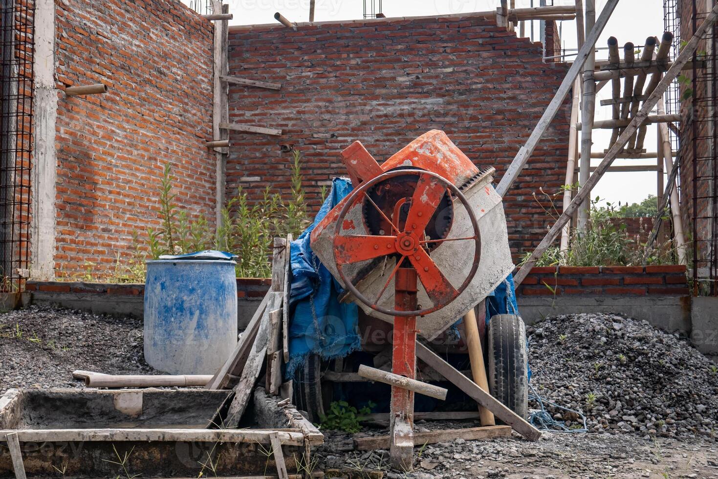 the cement mixer machine which is not being used is in the house construction area photo