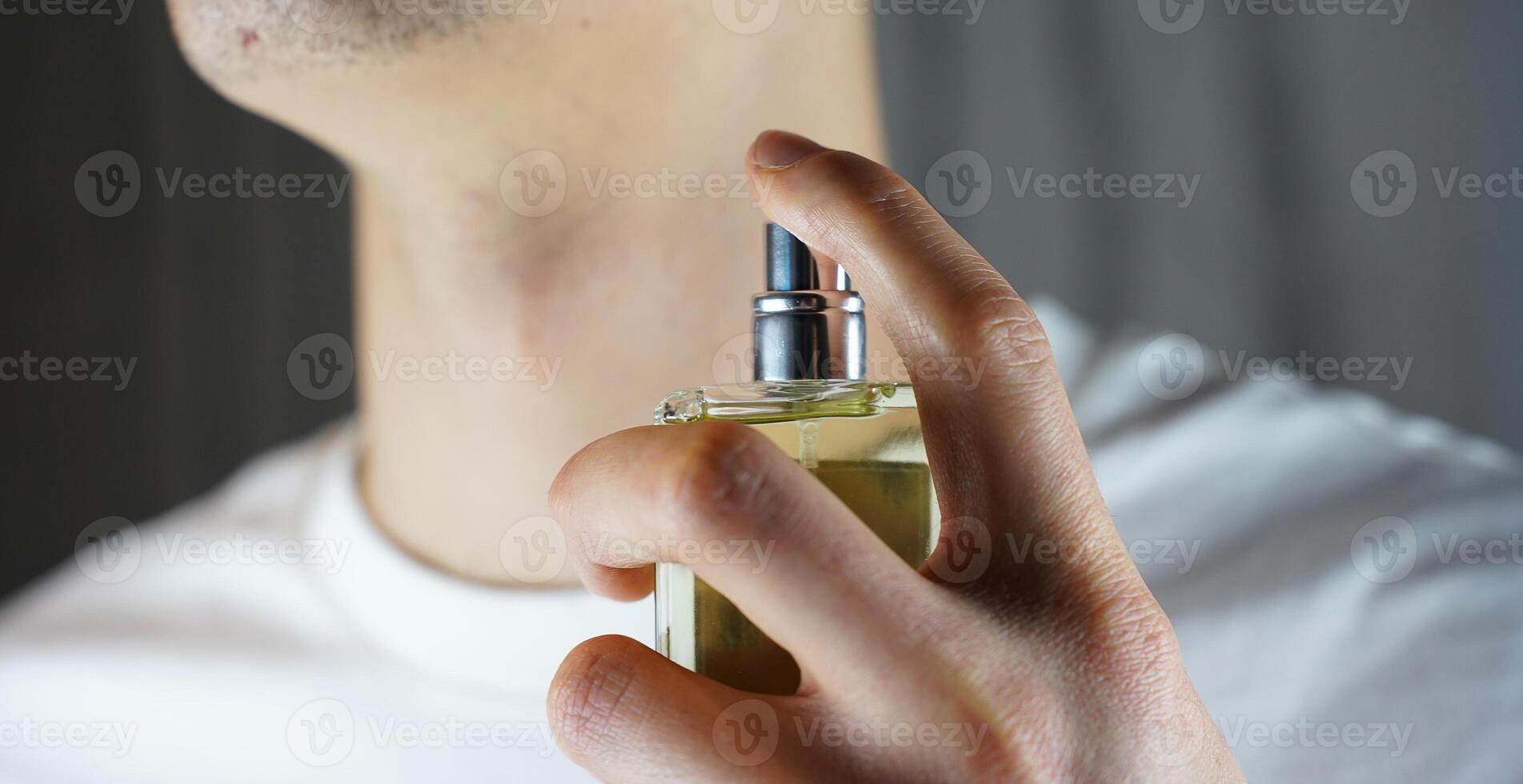persona pulverización perfumes en el cuello. hombre utilizando Colonia. foto