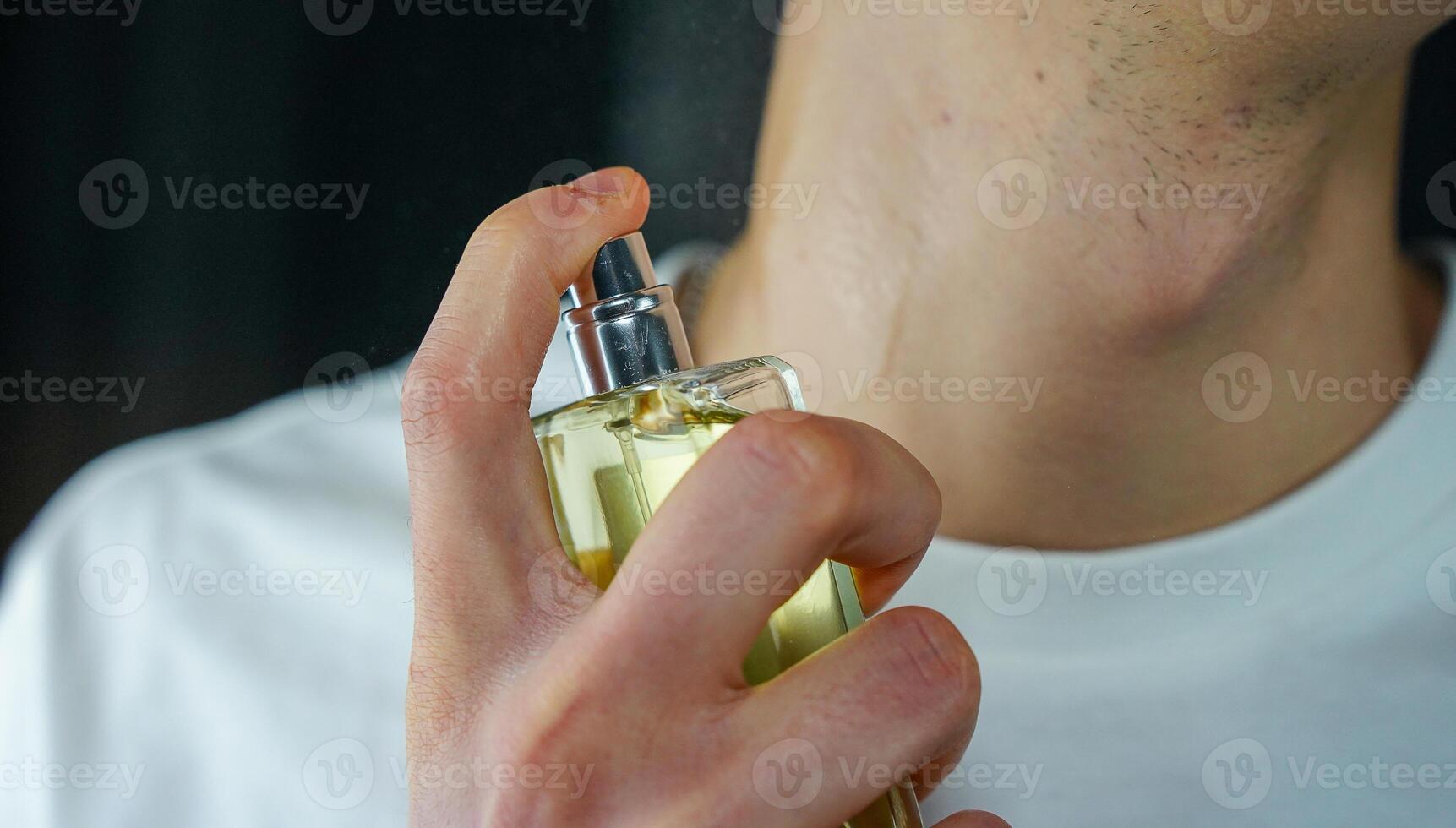 persona pulverización perfumes en el cuello. hombre utilizando Colonia. foto