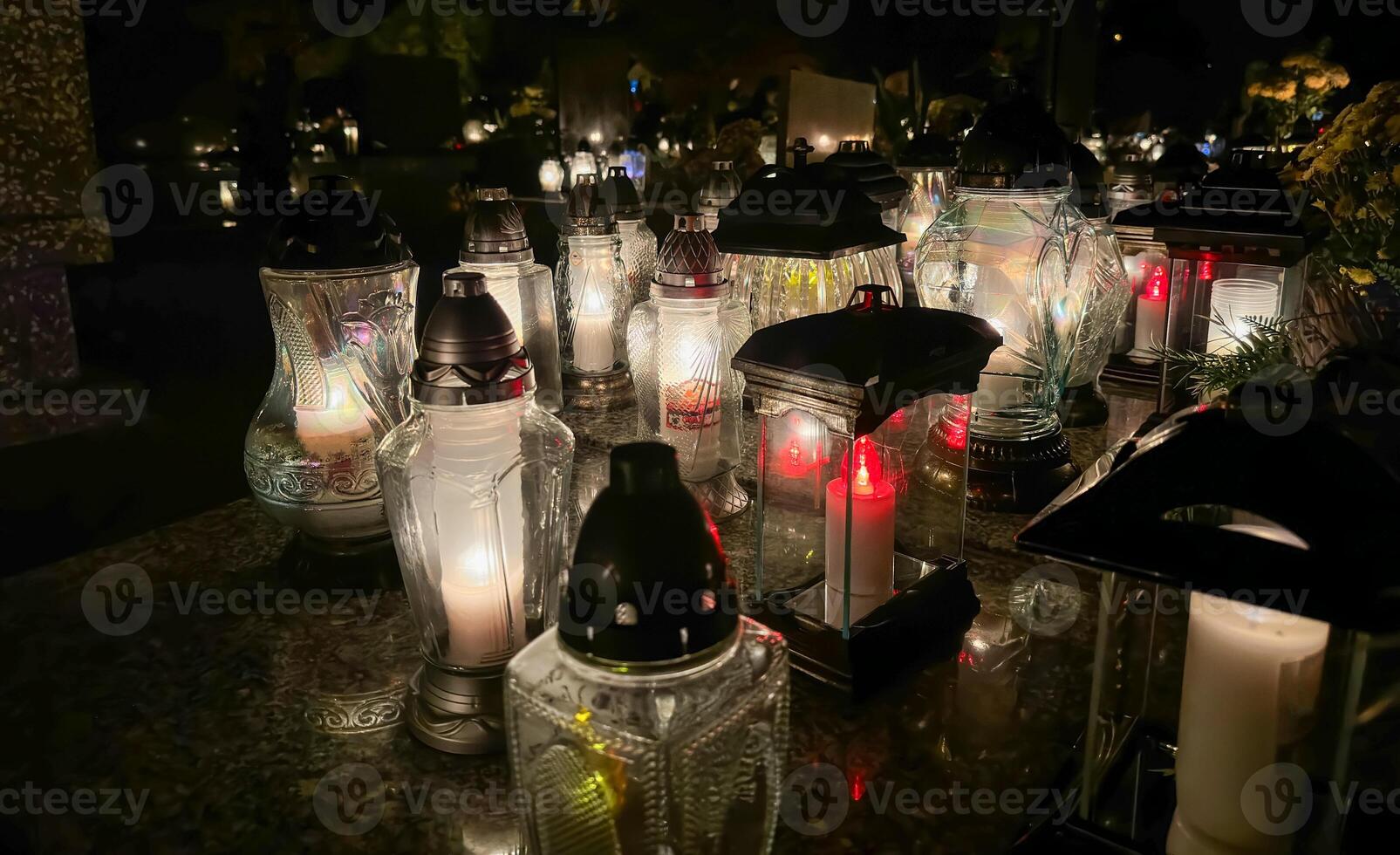 tumba velas en el tumba durante el todas santos día. cementerio velas con hermosa luces y flores cementerio durante el todas almas día. foto