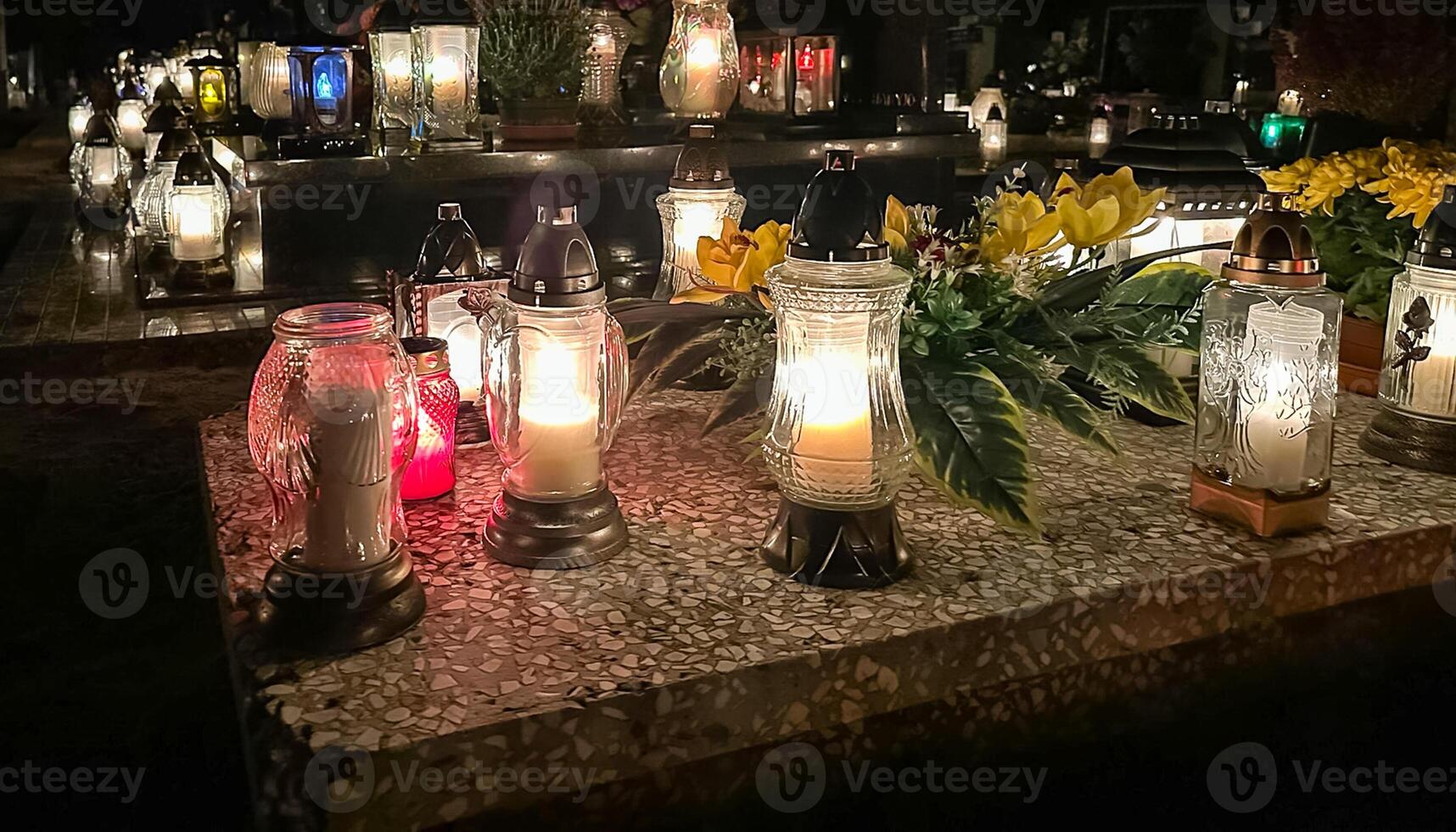 tumba velas en el tumba durante el todas santos día. cementerio velas con hermosa luces y flores cementerio durante el todas almas día. foto