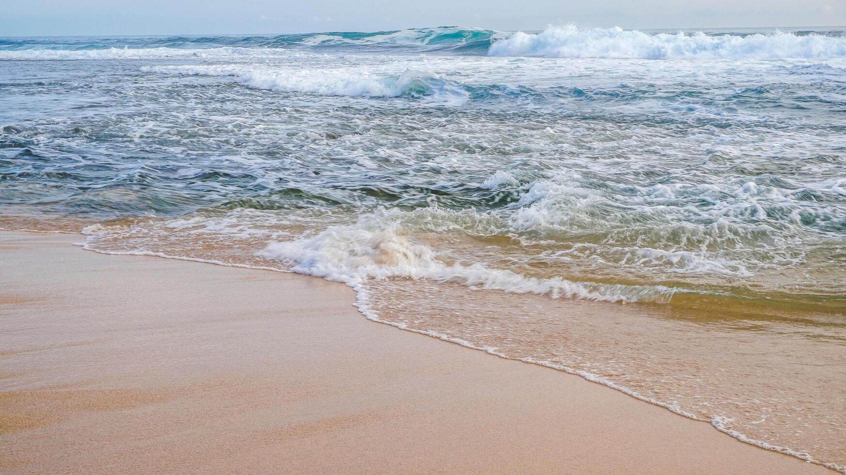 waves crashing on the white sand beach photo