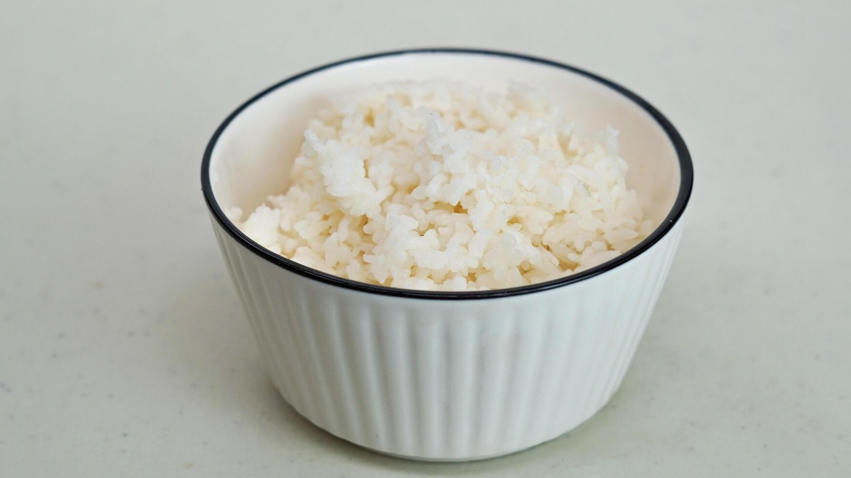 White rice in a white bowl with chopsticks photo