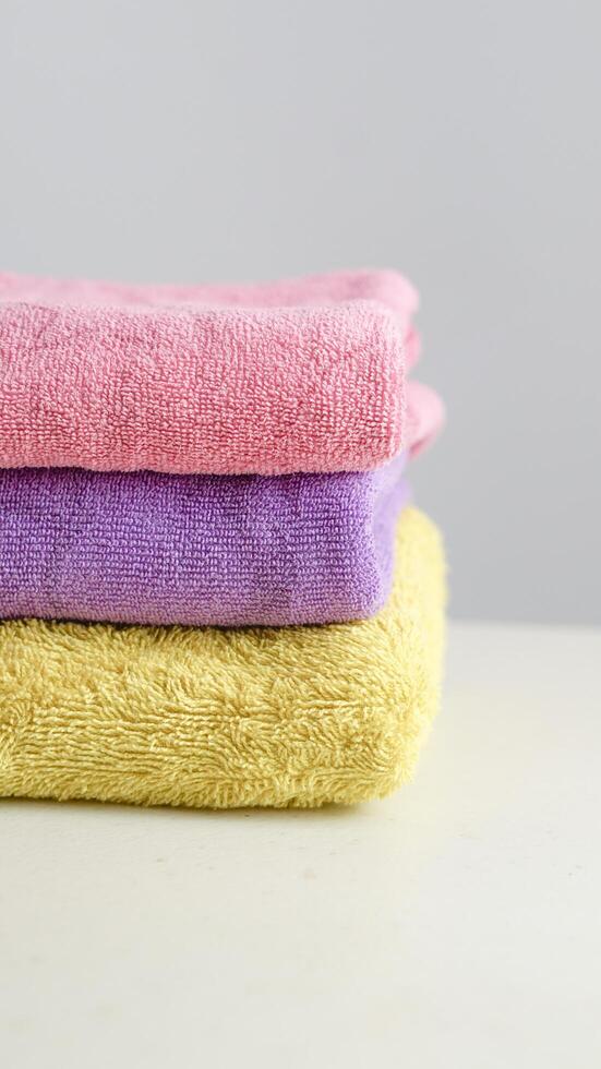 a pile of clean, folded and colored towels on a white background photo