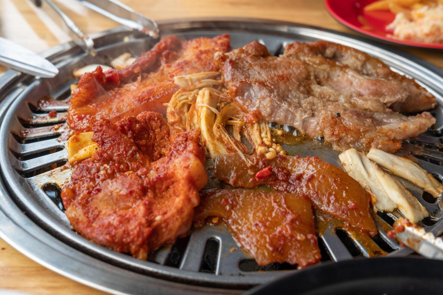 Grilled meat marinated in Korean sauce on a grill in a restaurant photo
