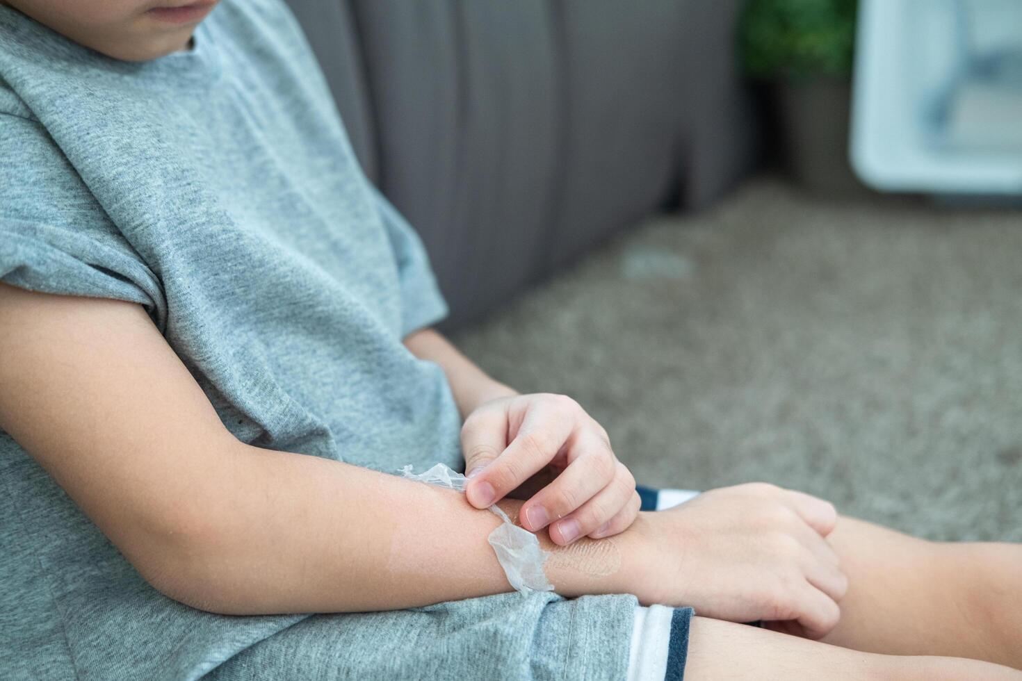 pequeño asiático Niños manos peladura apagado seco piel en su brazo. piel problemas. foto