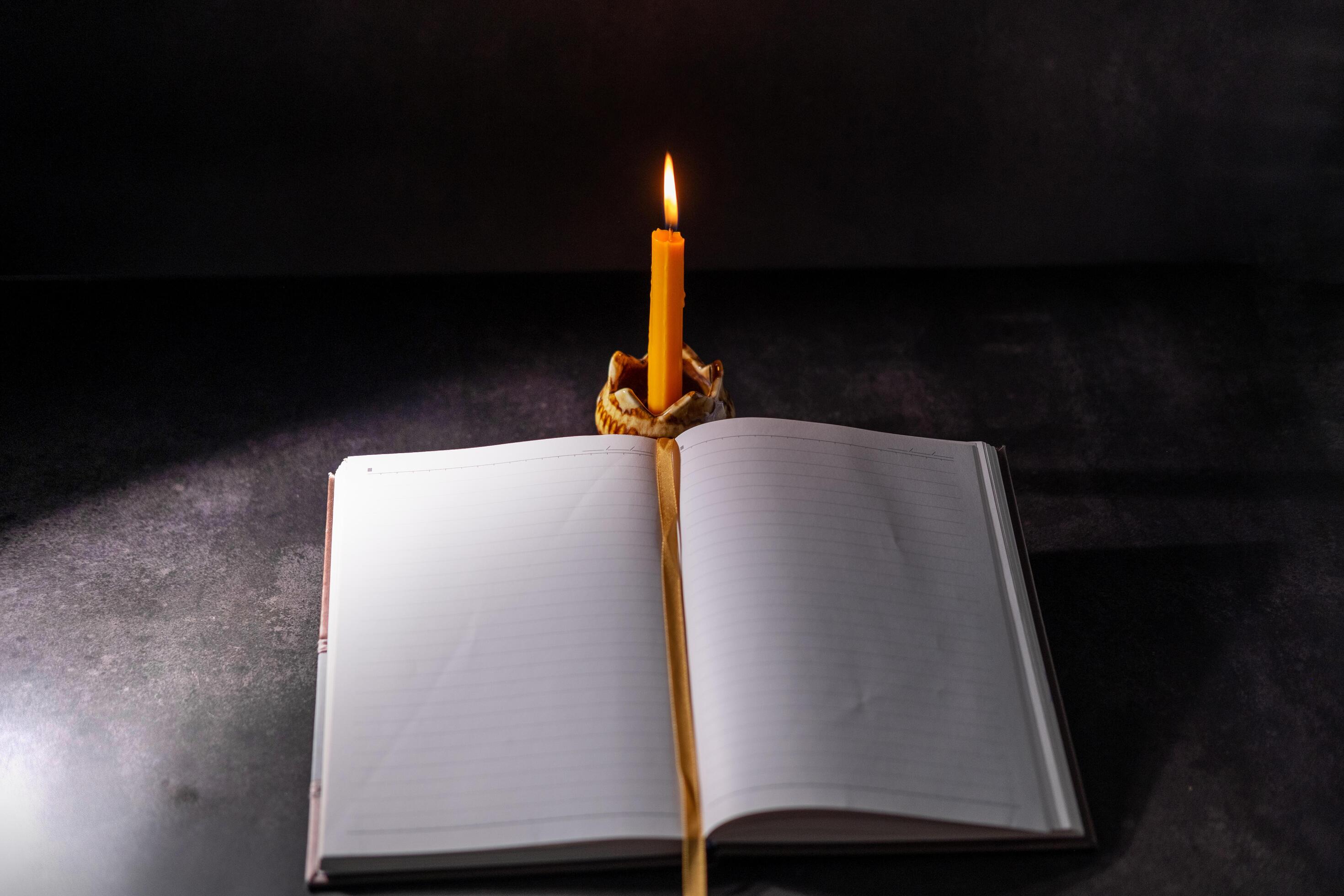 Yellow candlestick gives light while reading, black background 38075323