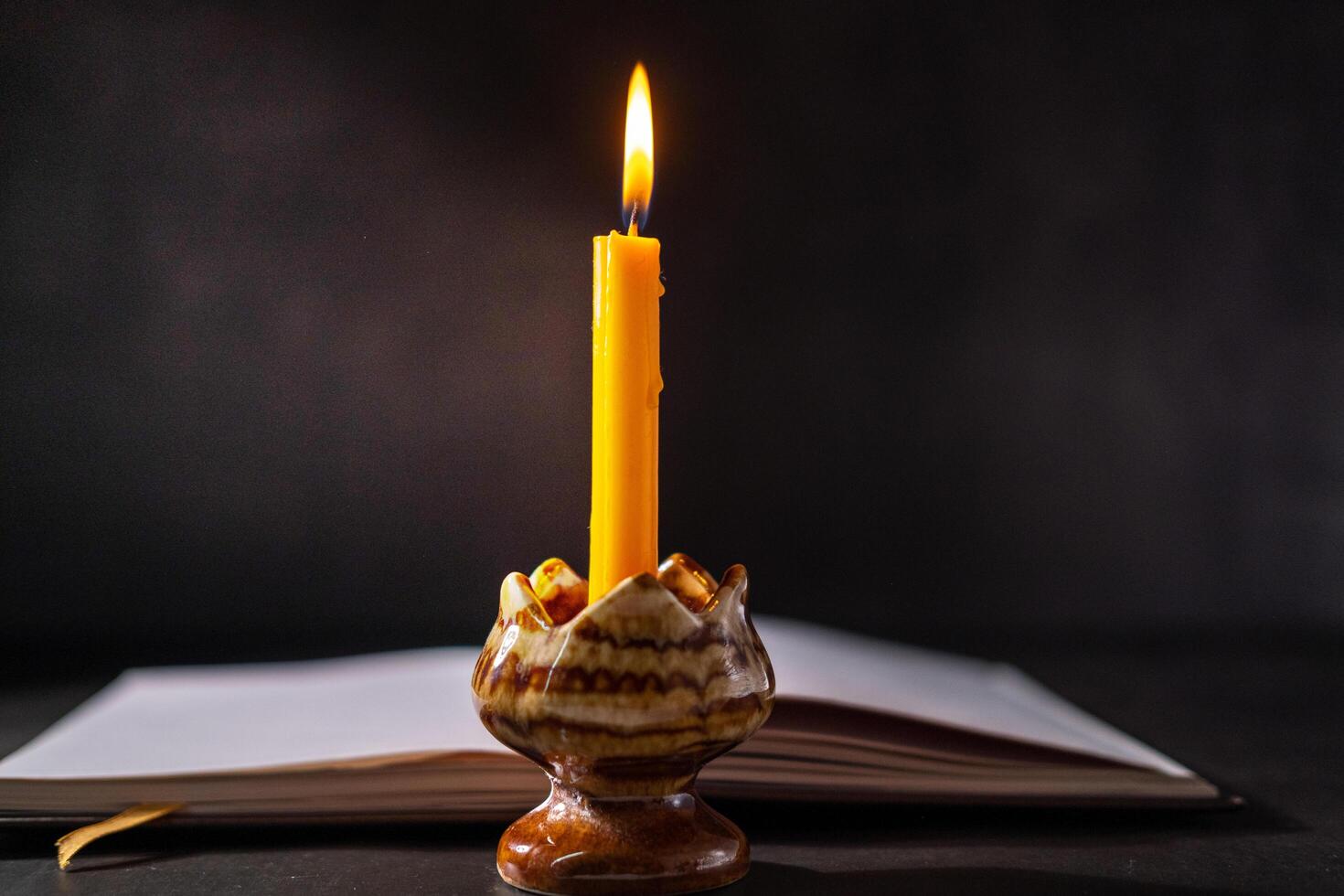 Yellow candlestick gives light while reading, black background 38075336