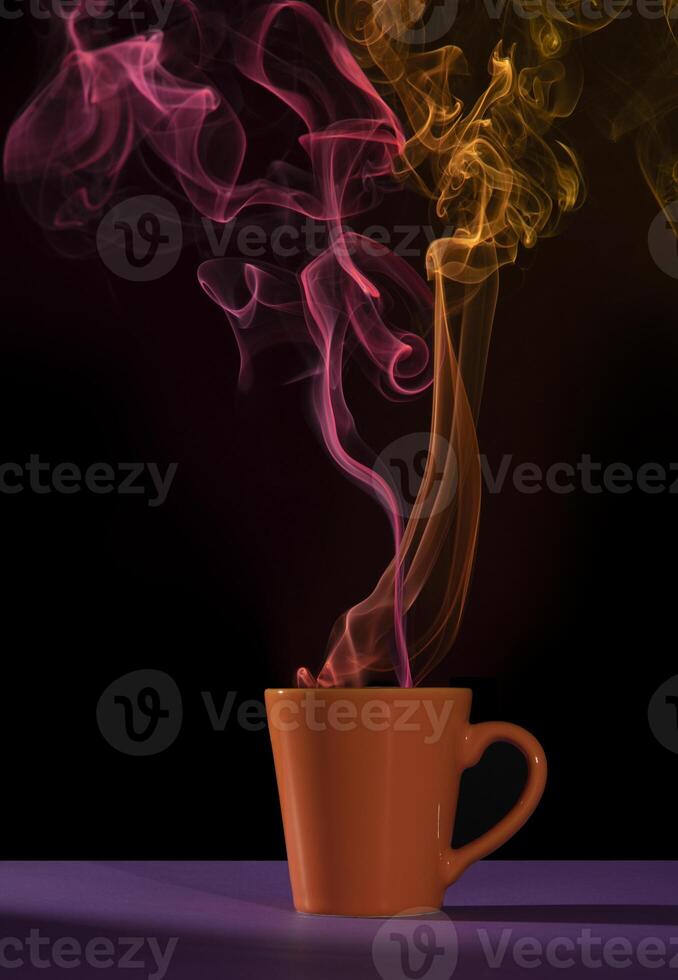 Orange cup of coffee on a purple table with red and yellow smoke photo