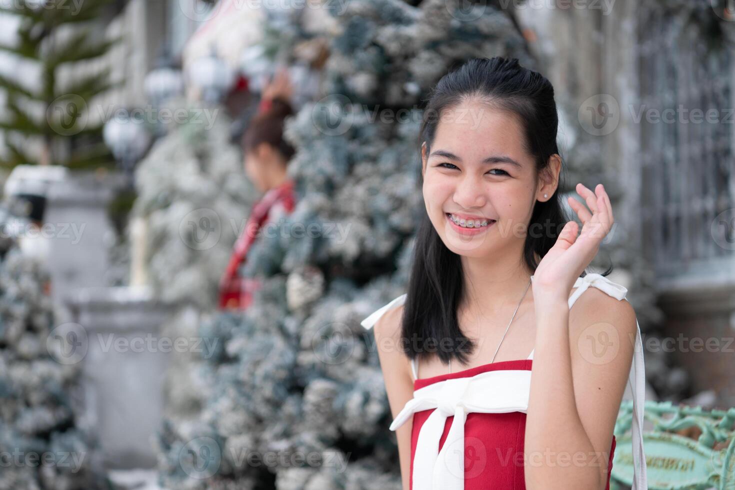 Portrait of teenage girl in a red dress relaxed and smiling in a snowy yard. photo