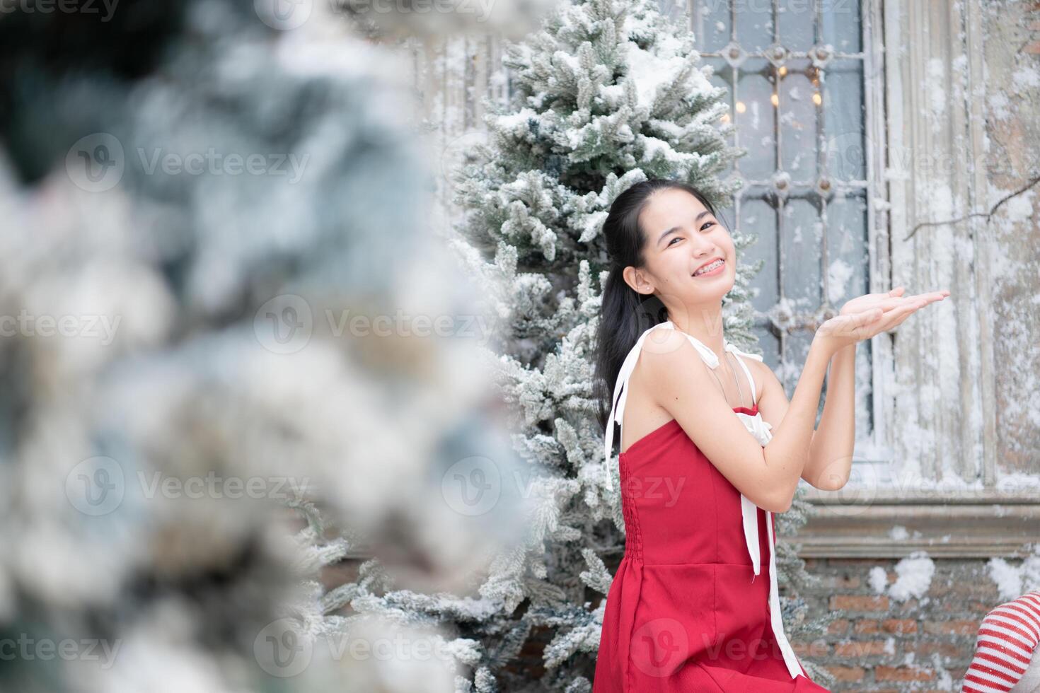 retrato de Adolescente niña en un rojo vestir relajado y sonriente en un Nevado patio trasero. foto