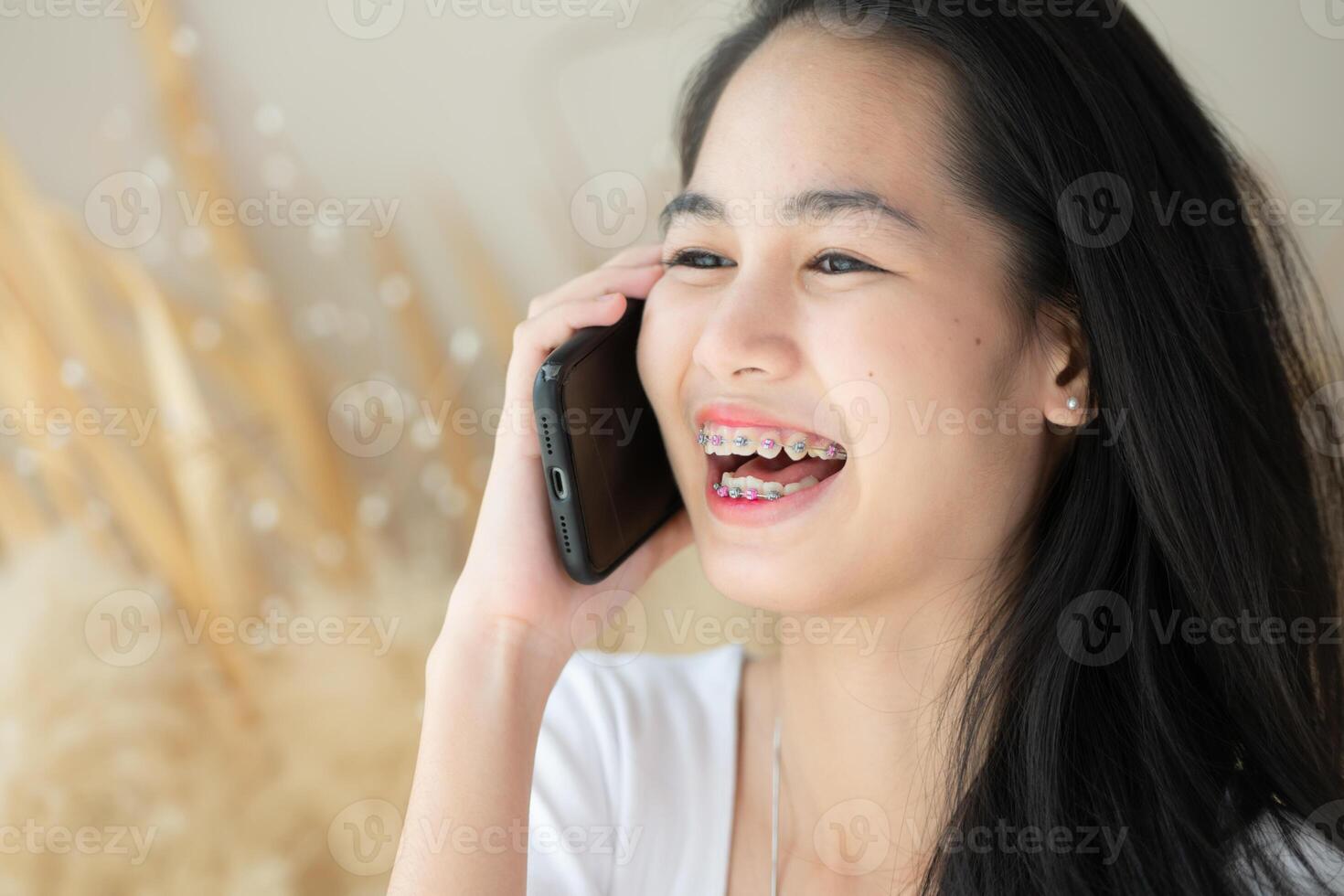 Portrait of Teenage girl talking on the phone with braces on her teeth. photo