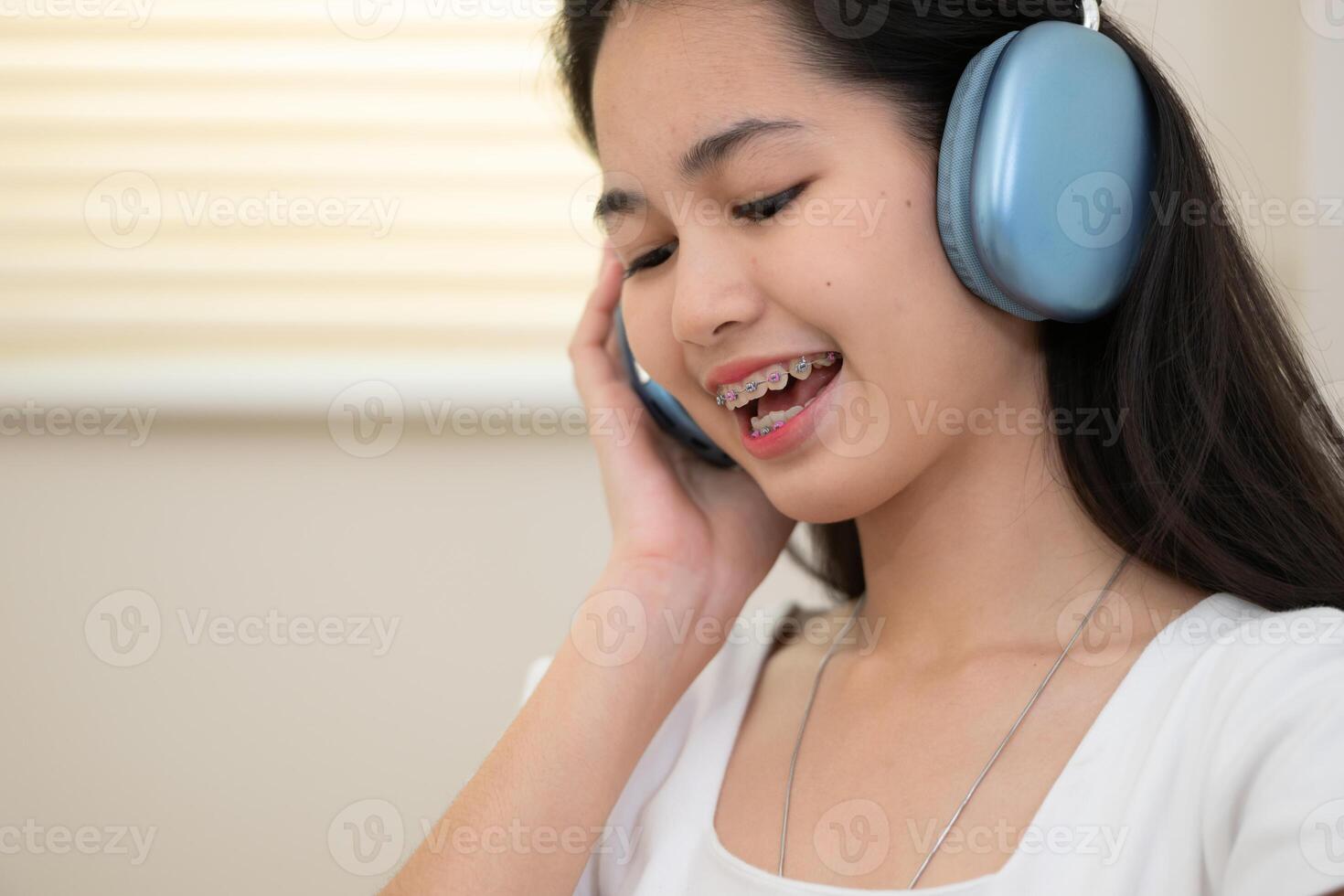 retrato de Adolescente niña escuchando a música con auriculares a hogar. foto