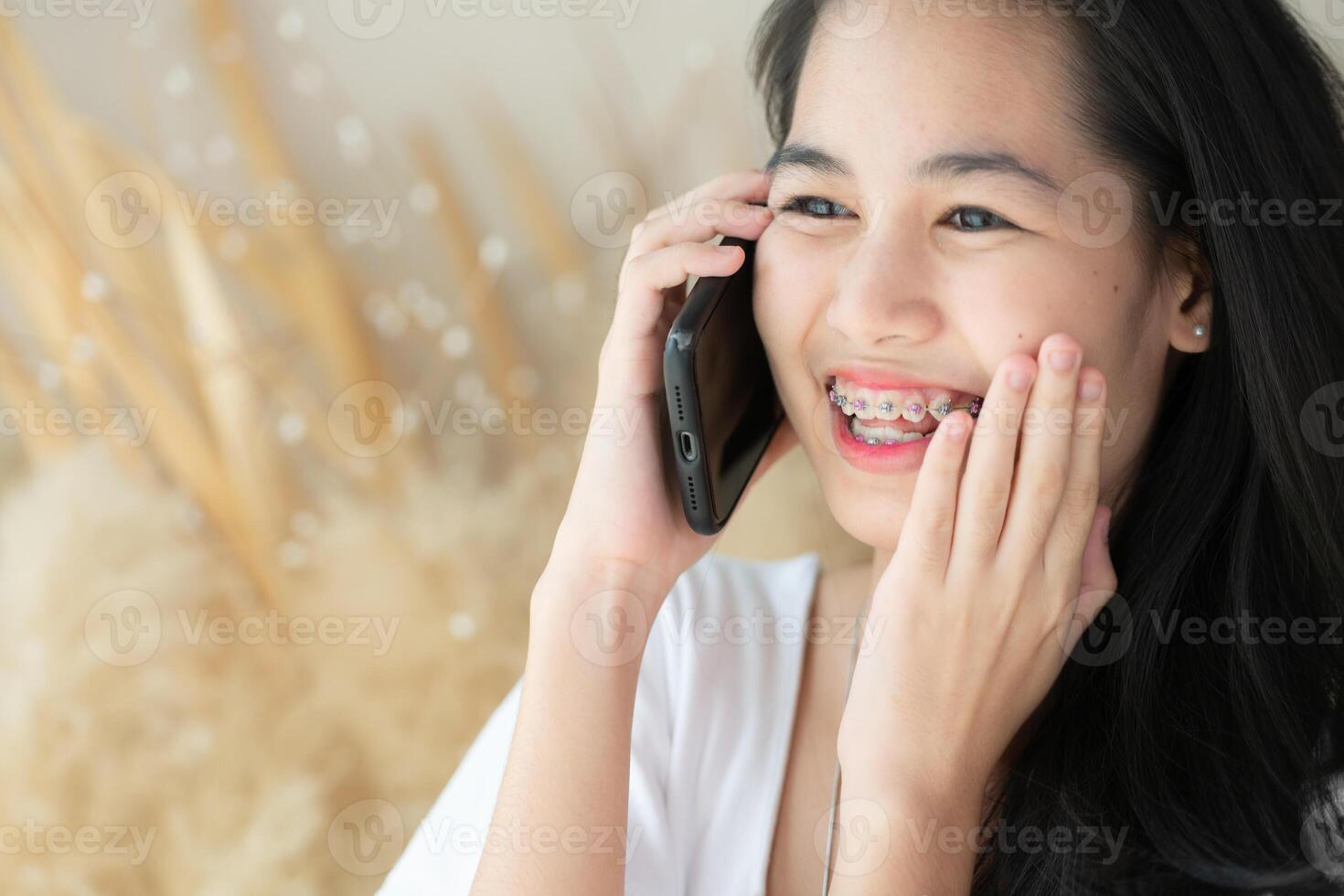 Portrait of Teenage girl talking on the phone with braces on her teeth. photo