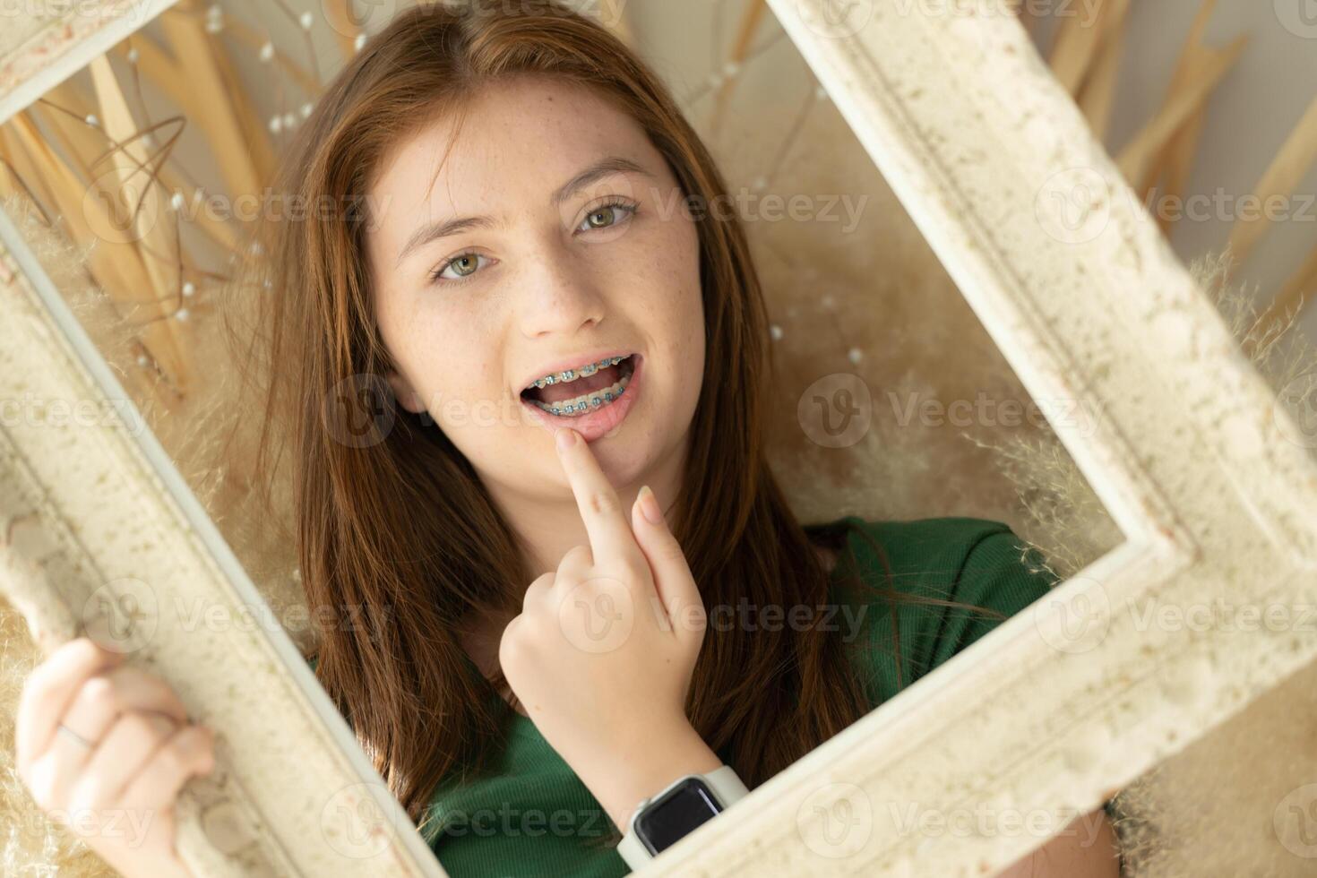 Portrait of Teenage girl with braces in picture frame photo