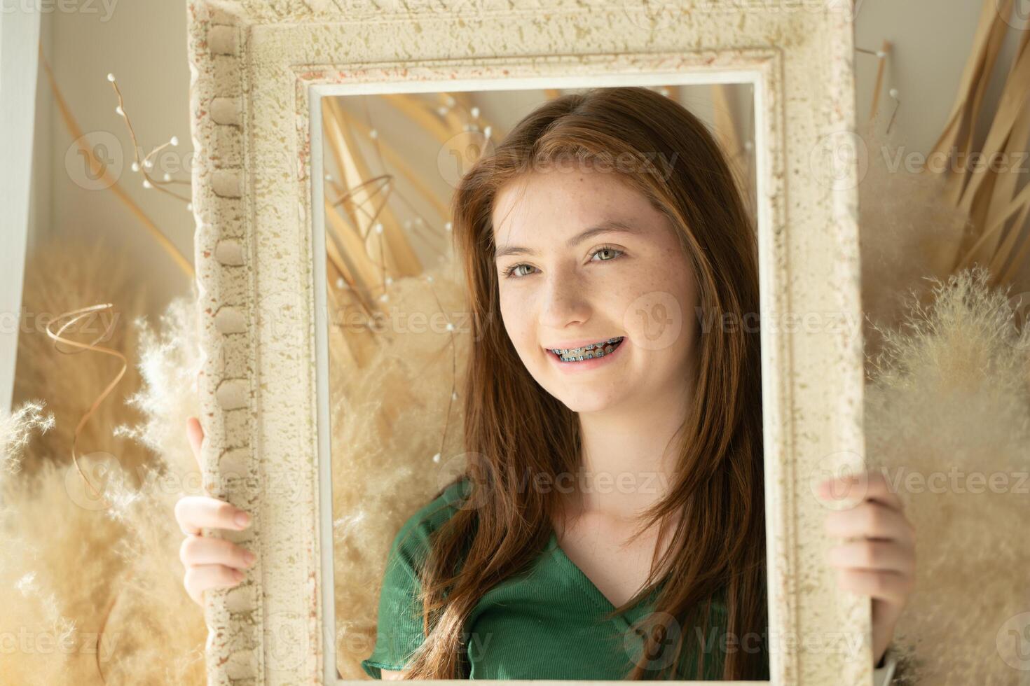 Portrait of Teenage girl with braces in picture frame photo