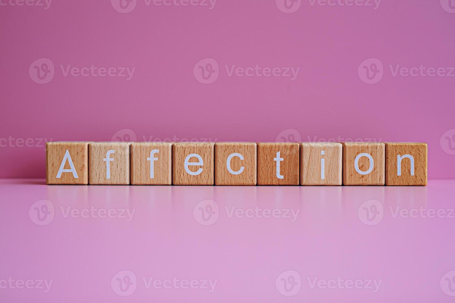 Wooden blocks form the text Affection against a pink background. photo