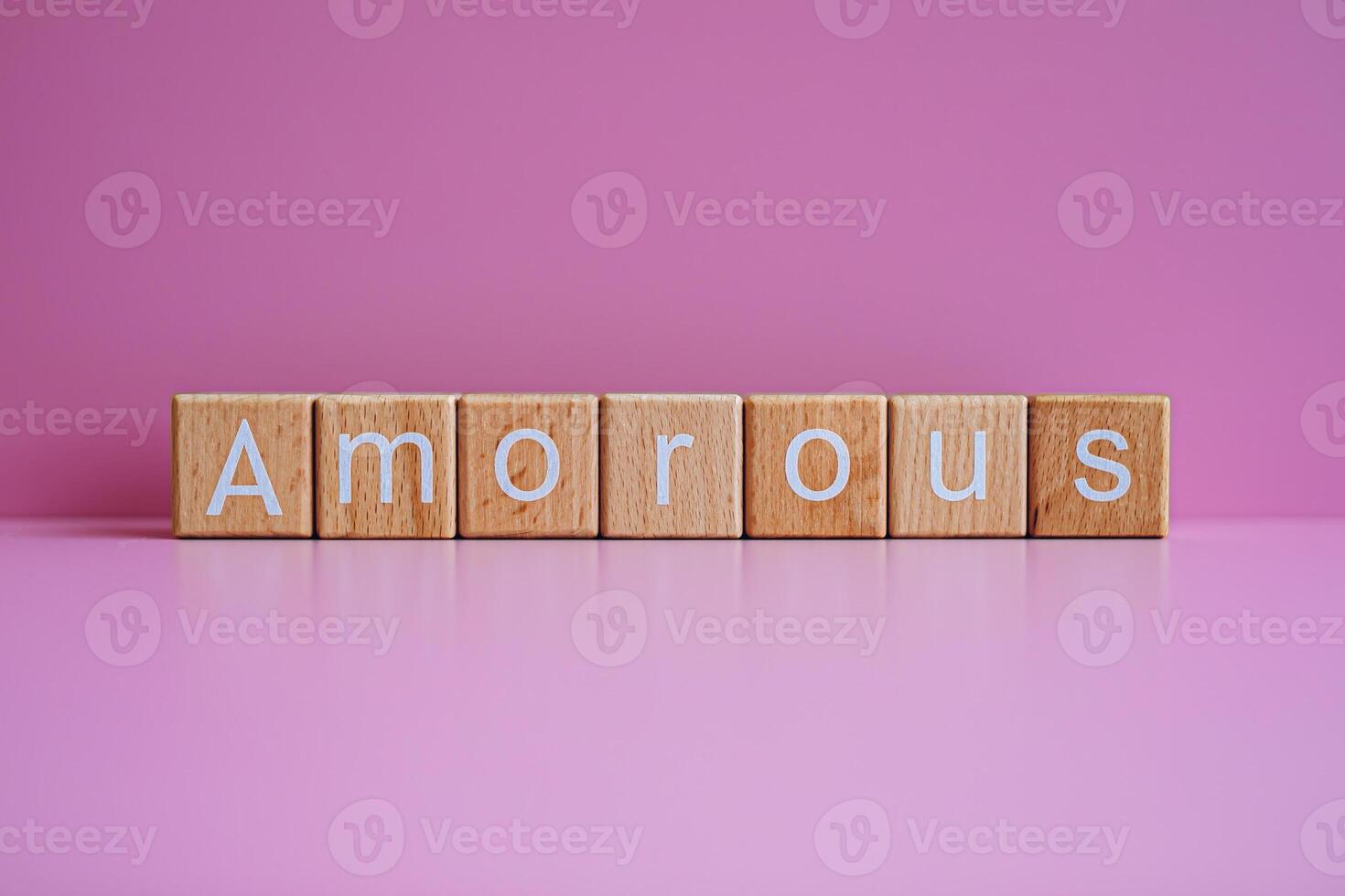 Wooden blocks form the text Amorous against a pink background. photo