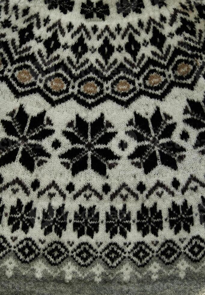 Black and white Winter Knitted Sweater Pattern Design with snowflakes. Handmade knitting wool fabric texture. Background of kniting patterns and ornament. photo