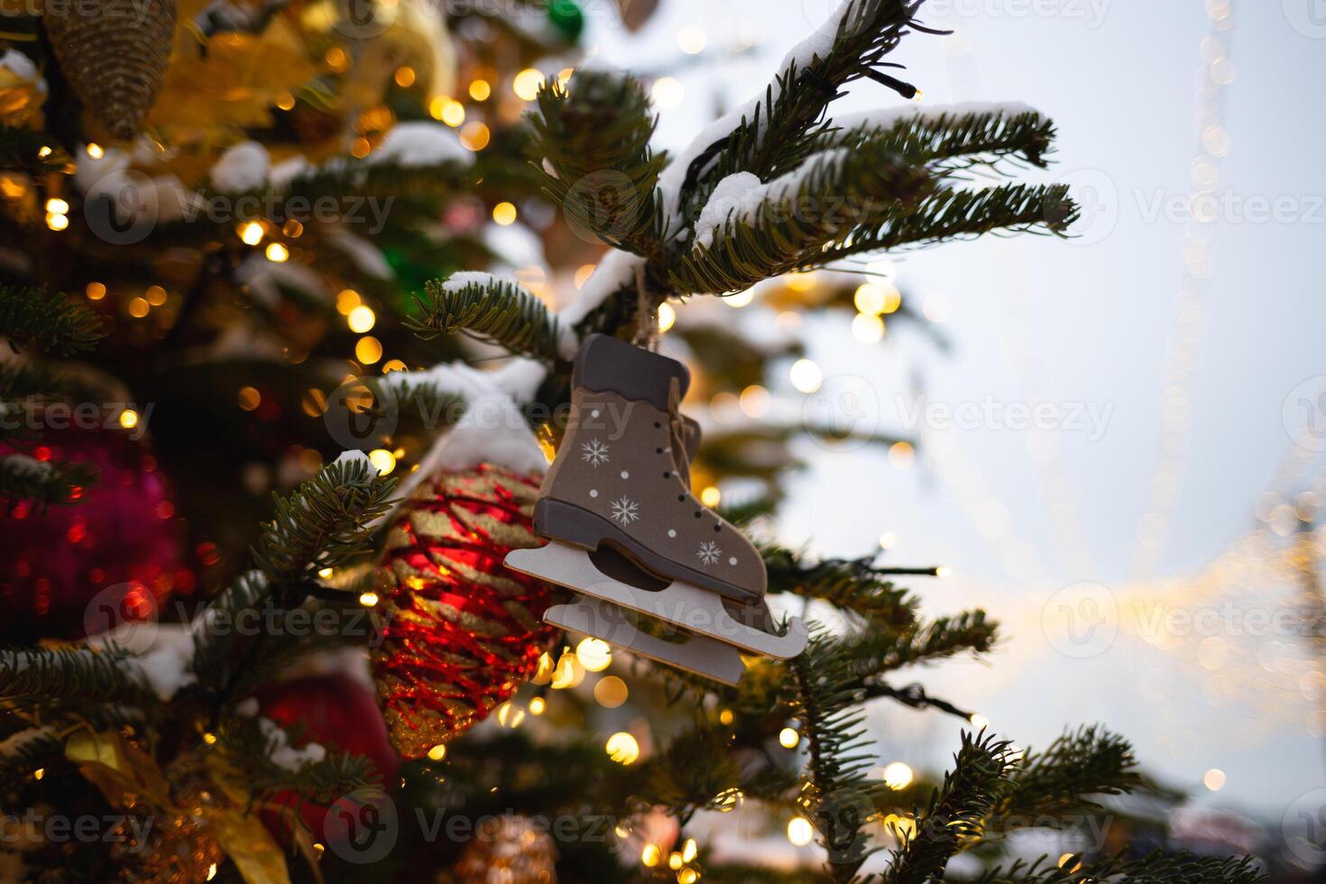 beautiful multi-colored toys on a Christmas tree against the background of lights and snow photo