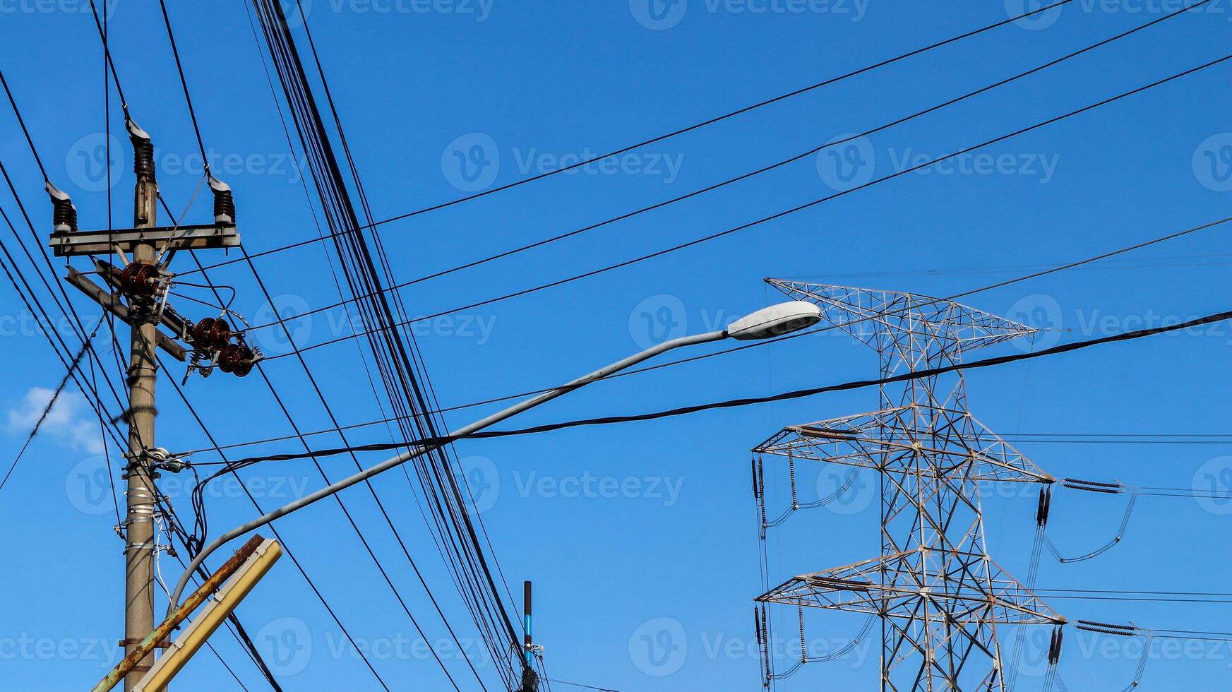 eléctrico alambres y eléctrico polos cruce el alto voltaje polo torre en contra el azul cielo antecedentes. foto