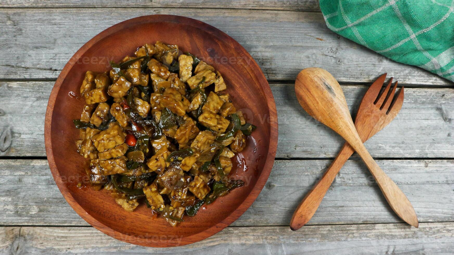 Orek tempe or Sauteed Tempe is a typical Indonesian cuisine with herbs, garlic, onion, chilli, long beans and soy sauce. it tastes delicious. isolated on grey background photo