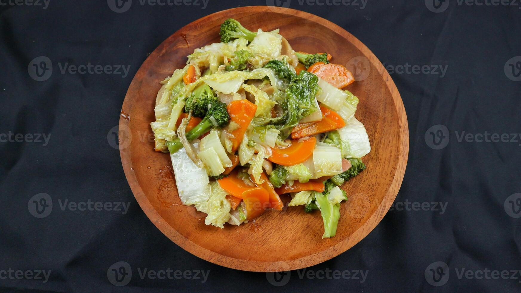 Fried capcay or cap cai or Hokkien is a mixture of vegetables stir-fried with chicken other dishes. Isolated on black background. photo