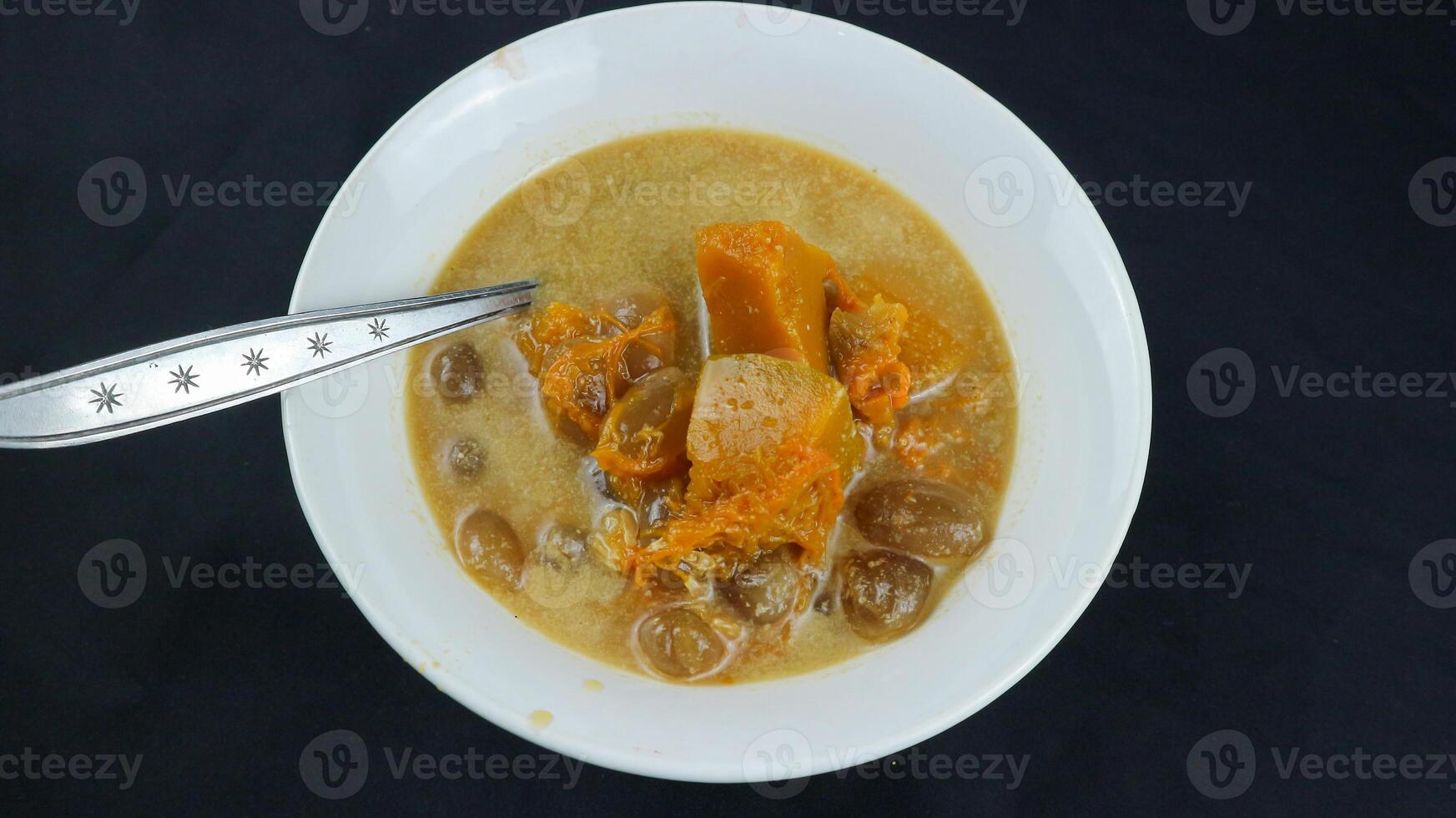 Kolak pisang or banana and pumpkin is popular Indonesian dessert made from banana, pumpkin, sugar palm fruit cooked with coconut milk, palm sugar and pandanus leaves. Very popular during Ramadhan. photo