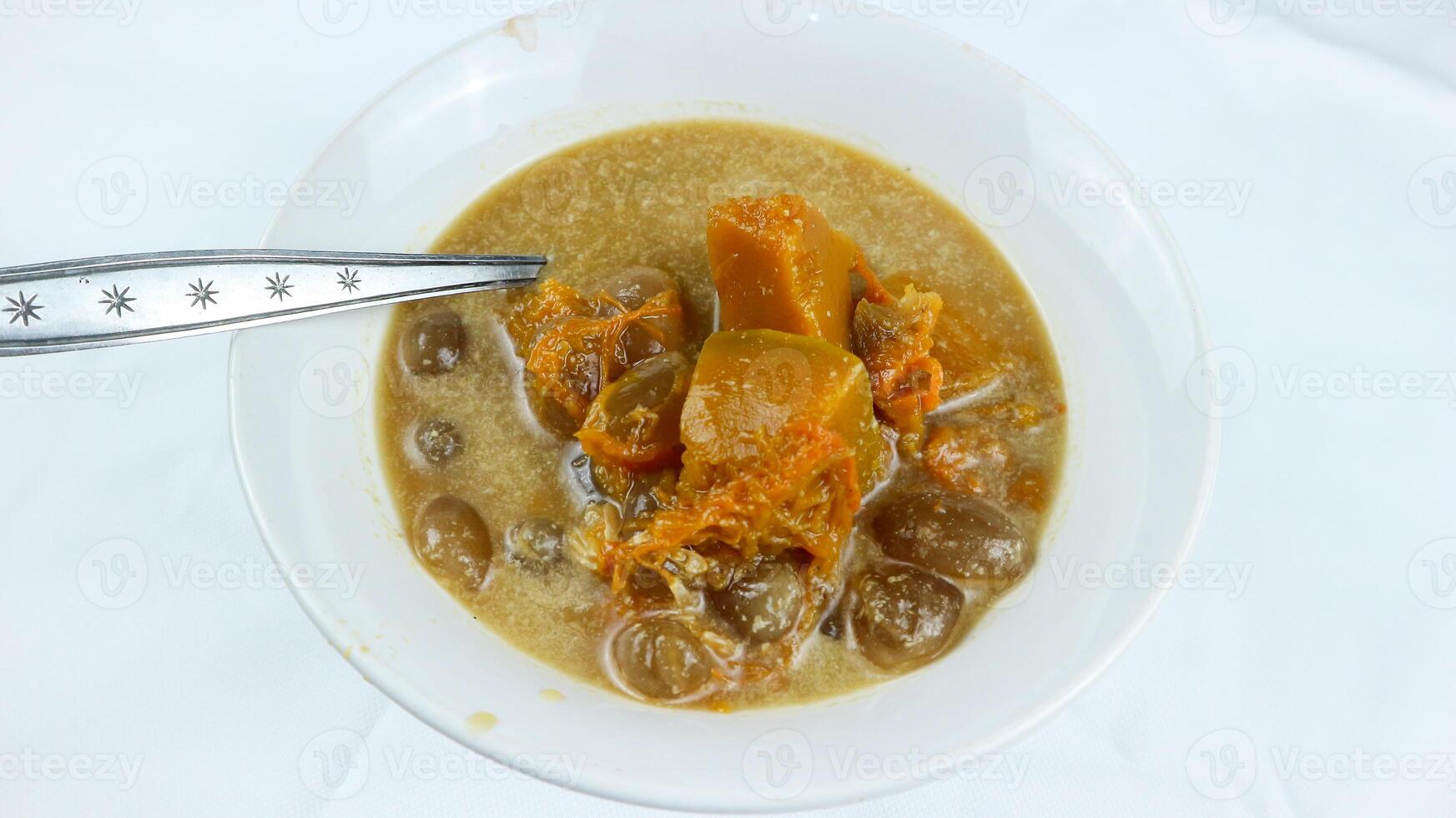 Kolak pisang or banana and pumpkin is popular Indonesian dessert made from banana, pumpkin, sugar palm fruit cooked with coconut milk, palm sugar and pandanus leaves. Very popular during Ramadhan. photo