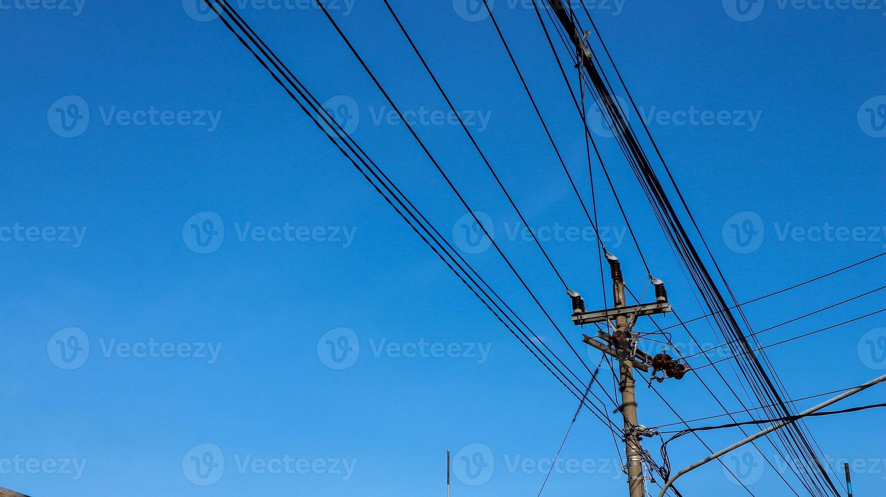 eléctrico alambres y eléctrico polos cruce el alto voltaje polo torre en contra el azul cielo antecedentes. foto