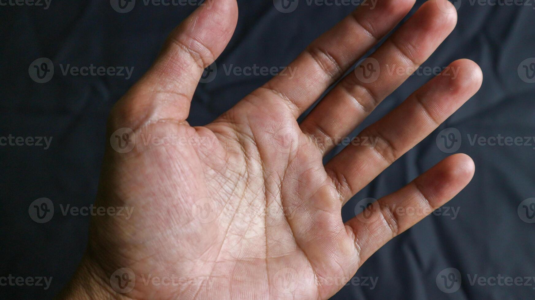 The empty hand shows the gesture of holding a bottle, smartphone or something isolated on a black background with a clipping path. photo